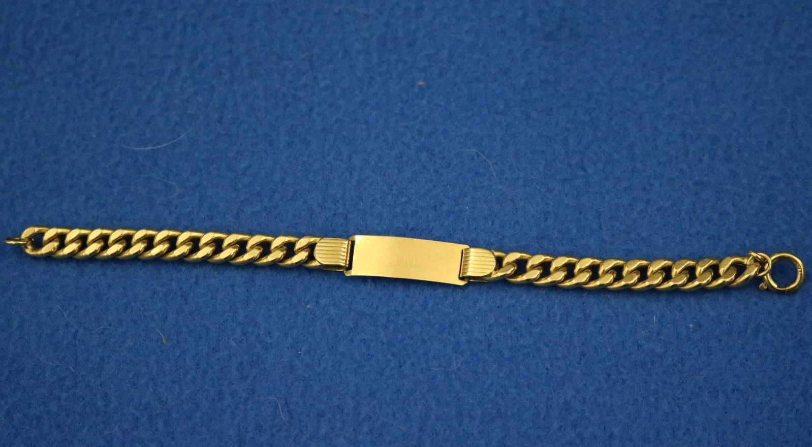 18K (750) BRIGHT-POLISHED YELLOW GOLD FLEXIBLE-LINK ID BRACELET - L: 6 1/4 in. Wt. 5 dwt.: 18K (750) BRIGHT-POLISHED YELLOW GOLD FLEXIBLE-LINK ID BRACELET Flattened curb link chain centers rectangular panel suitable for engraving L: 6 1/4 in. Wt. 5 dwt
