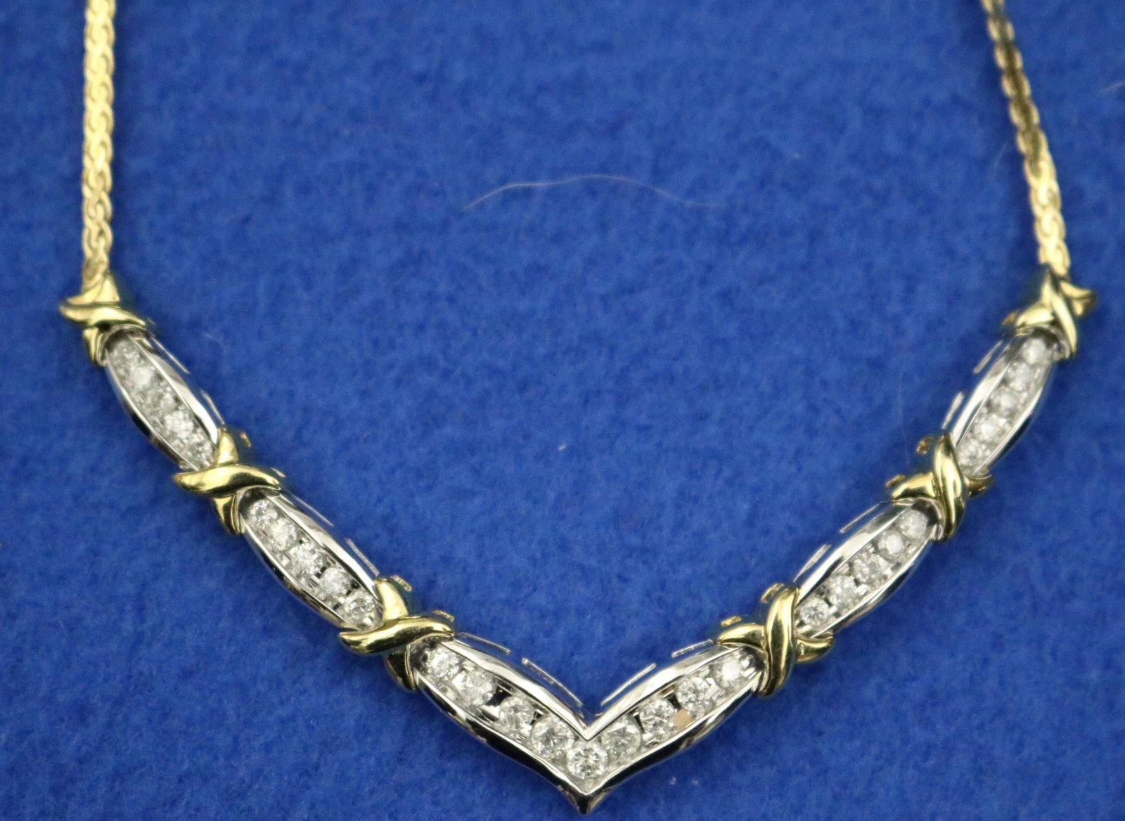 10K YELLOW AND WHITE GOLD AND DIAMOND CHOKER - Total diamond weight app. 1.50 ct. L: 17 in. Gross: 10K YELLOW AND WHITE GOLD AND DIAMOND CHOKER Chevron shape throat portion constructed of white gold links with 29 graduated brilliant-cut round diamonds, alternating with six yellow gold X-form link, 