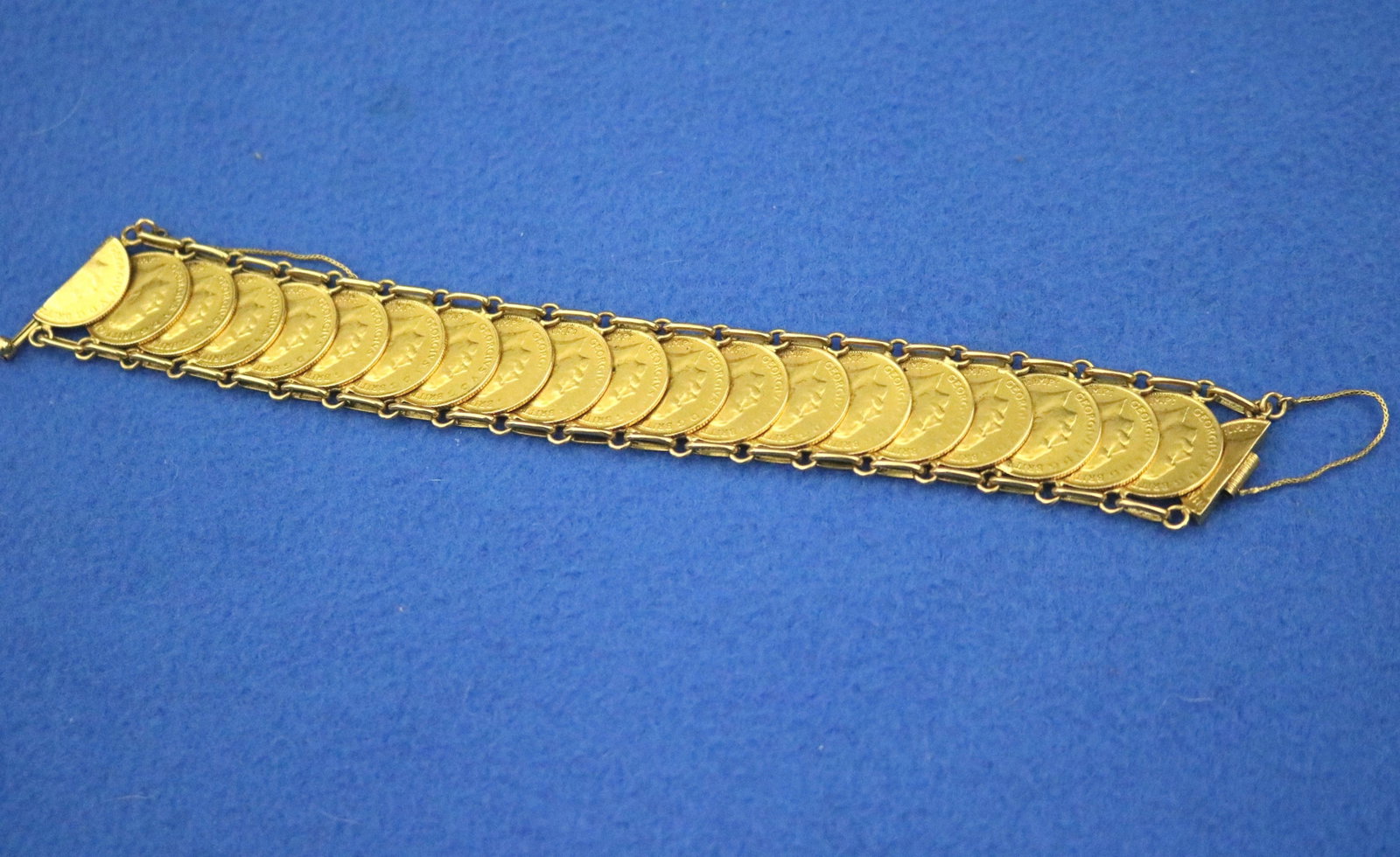 18K YELLOW GOLD AND BRITISH HALF-SOVEREIGN FLEXIBLE-LINK COIN BRACELET - L: 7 3/4 in. W: 1 in. Wt. 3: 18K YELLOW GOLD AND BRITISH HALF-SOVEREIGN FLEXIBLE-LINK COIN BRACELET Row of 19 overlapping half-sovereigns all dated 1913 with 20th sovereign bisected for clasp, chain link borders; sliding pin clas