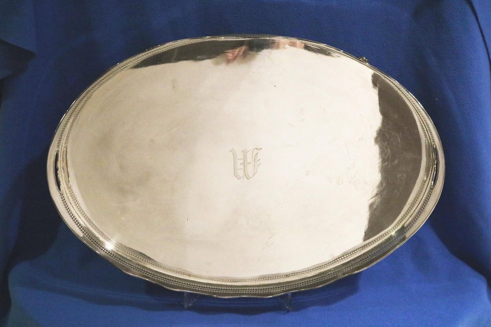 GEORGE III STYLE SILVER-ON-COPPER OVAL SERVING TRAY WITH PIERCED SERPENTINE GALLERY - 23 1/4 in. x: GEORGE III STYLE SILVER-ON-COPPER OVAL SERVING TRAY WITH PIERCED SERPENTINE GALLERY Cut-out handholds; raised on four cast leafy feet 23 1/4 in. x 15 3/4 in.