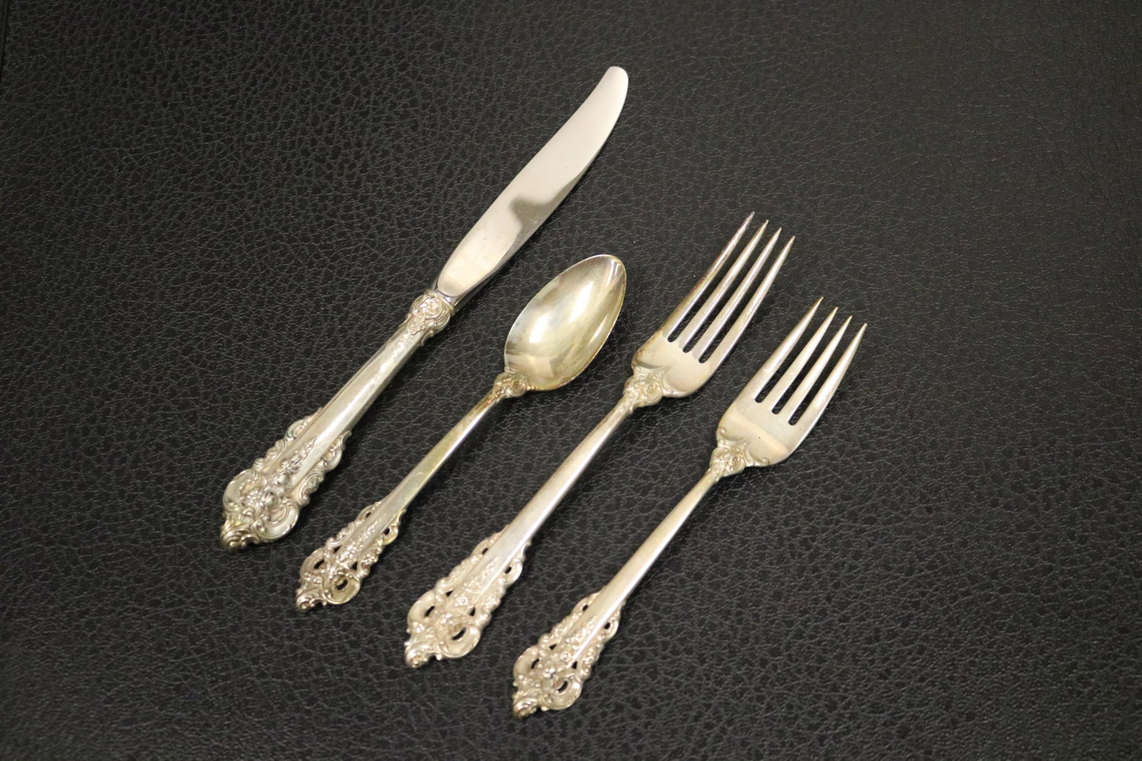 26-PIECE PARTIAL SERVICE WALLACE CO. "GRAND BAROQUE" PATTERN STERLING SILVER FLATWARE - Wt. 29 troy: 26-PIECE PARTIAL SERVICE WALLACE CO. "GRAND BAROQUE" PATTERN STERLING SILVER FLATWARE Including 8 dinner knives, L: 8 7/8 in.; 7 dinner forks, L: 7 1/4 in.; 6 salad/dessert forks; and 5 teaspoons Wt.