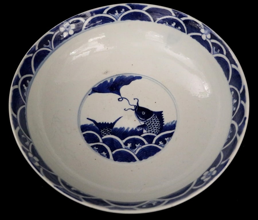 CHINESE BLUE AND WHITE PORCELAIN CHENGHUA NIANZHI-STYLE SHALLOW BOWL. Cobalt blue underglaze: CHINESE BLUE AND WHITE PORCELAIN CHENGHUA NIANZHI-STYLE SHALLOW BOWL. Cobalt blue underglaze painting on white porcelain body. Central medallion of stylized fish swimming in wave and nibbling on gingk