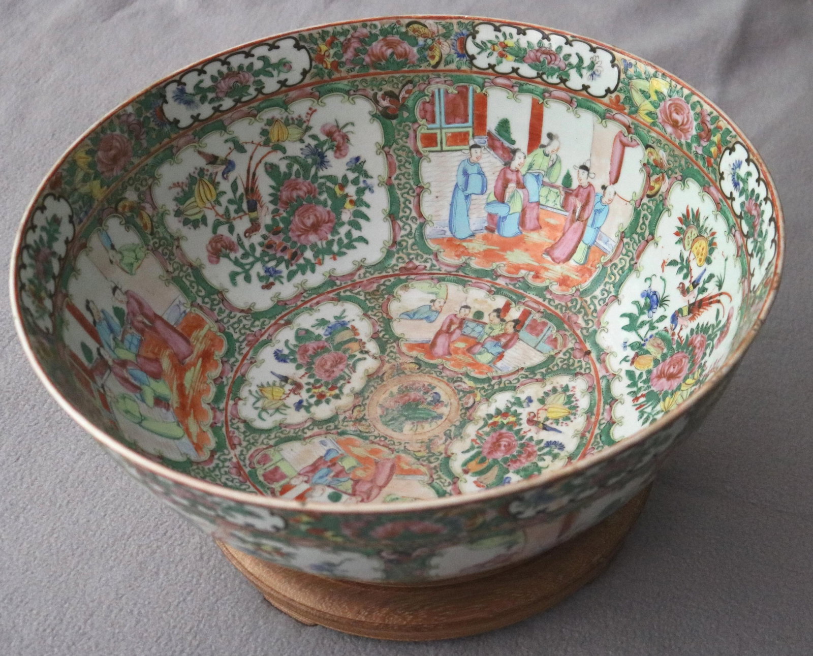 CHINESE FAMILLE ROSE PORCELAIN PUNCH BOWL 19th century. - D: 16 in..: CHINESE FAMILLE ROSE PORCELAIN PUNCH BOWL 19th century. Decorated with alternating shaped panels of court figures in interior scenes and birds amongst peonies and foliage. On teak wood stand D: 16 in.