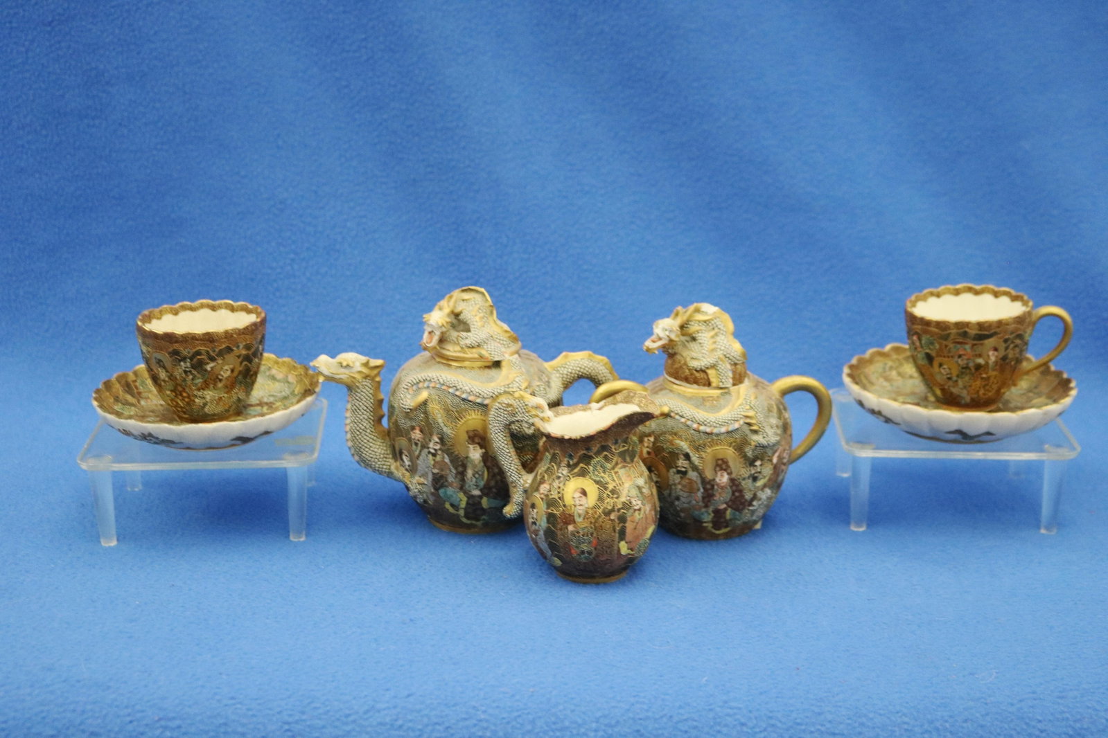 JAPANESE SATSUMA PORCELAIN TETE-A-TETE TYPE MINIATURE TEA SET late 19th century - H: 4 5/8 in..: JAPANESE SATSUMA PORCELAIN TETE-A-TETE TYPE MINIATURE TEA SET late 19th century Signed with gilt characters under each piece. Including teapot with cover, covered sugar bowl, creamer and two cups