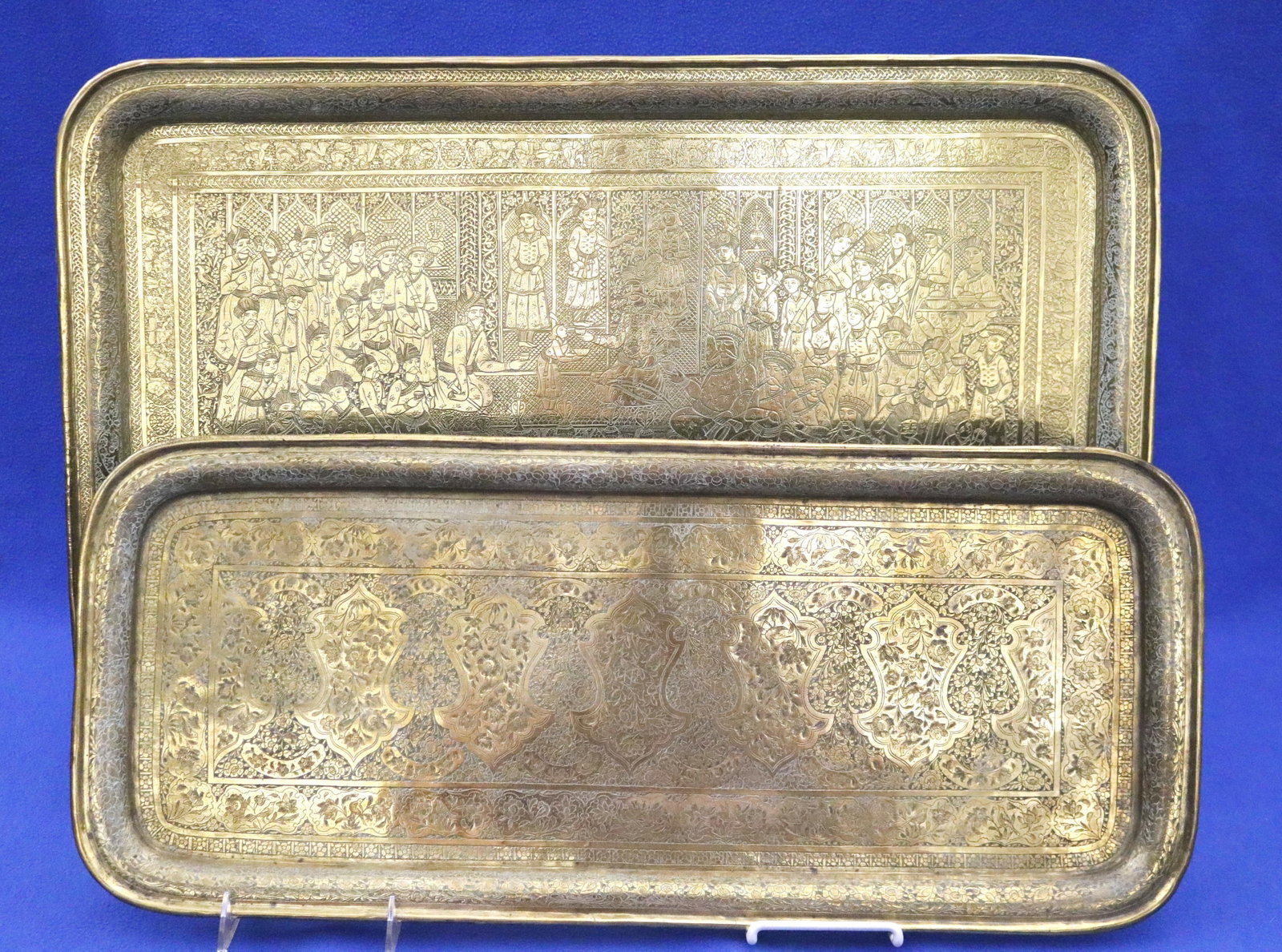 TWO VINTAGE INDIAN BRASS RECTANGULAR TRAYS - .: TWO VINTAGE INDIAN BRASS RECTANGULAR TRAYS One, with overall figural decoration, 27 in. x 18 in.; other, with overall floral and bird motifs, 25 3/4 in. x 10 7/8 in. Finely tooled