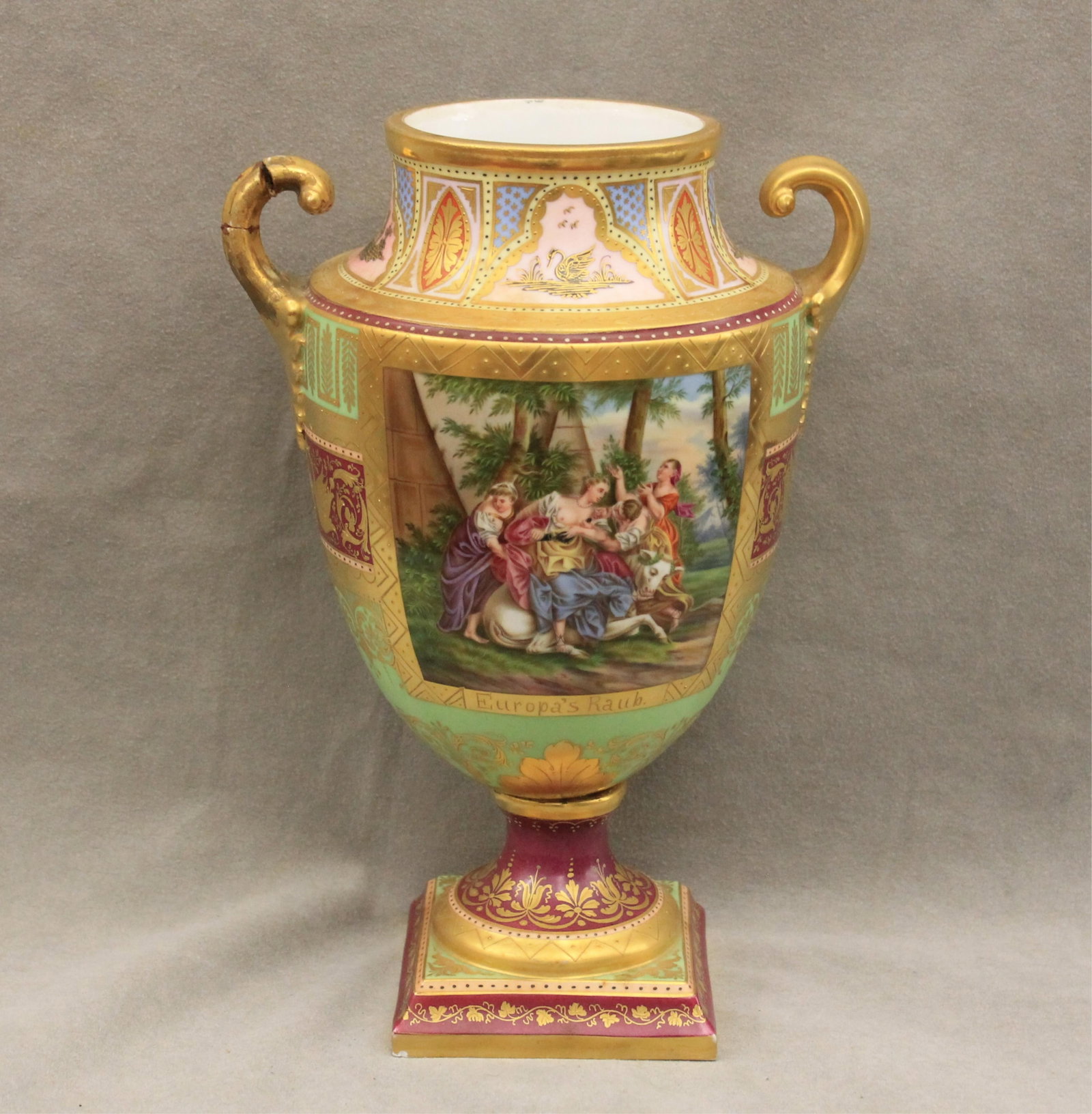 ROYAL VIENNA PAINTED PORCELAIN TWO-HANDLE URN 19th century - H: 11 1/2 in..: ROYAL VIENNA PAINTED PORCELAIN TWO-HANDLE URN 19th century Reserves of classical scenes, "Campaspe" and "Europa's Raub", on sea green and magenta ground with lavish gilt highlights H: 11 1/2 in.