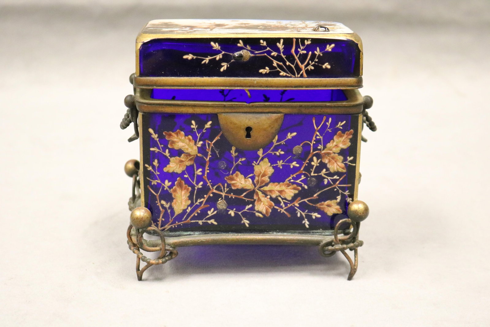 AESTHETIC MOVEMENT COBALT AND GILT GLASS HINGED-TOP RECTANGULAR BOX, POSSIBLY BY MOSER 19th century: AESTHETIC MOVEMENT COBALT AND GILT GLASS HINGED-TOP RECTANGULAR BOX, POSSIBLY BY MOSER 19th century Top decorated with scene of stag in snow landscape; floral branch painted front and sides with acorn