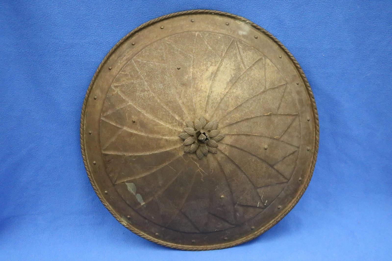 CIRCULAR METAL WARRIOR'S SHIELD 19th century - D: 21 3/8 in..: CIRCULAR METAL WARRIOR'S SHIELD 19th century Low relief decoration centers leafy medallion. D: 21 3/8 in.