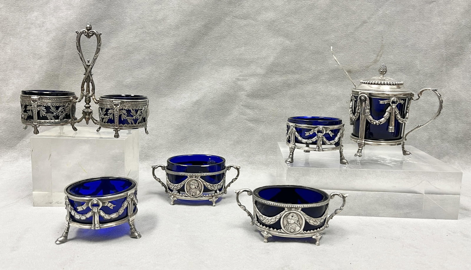 SIX FRENCH NEOCLASSICAL OPENWORK SILVER TABLE ARTICLES - Mustard pot (with non-associated sterling: SIX FRENCH NEOCLASSICAL OPENWORK SILVER TABLE ARTICLES Including: cylindrical, hinged-top footed mustard pot made by A. Aucoc, with pair matching silver circular open salts; pair oval open salts joine