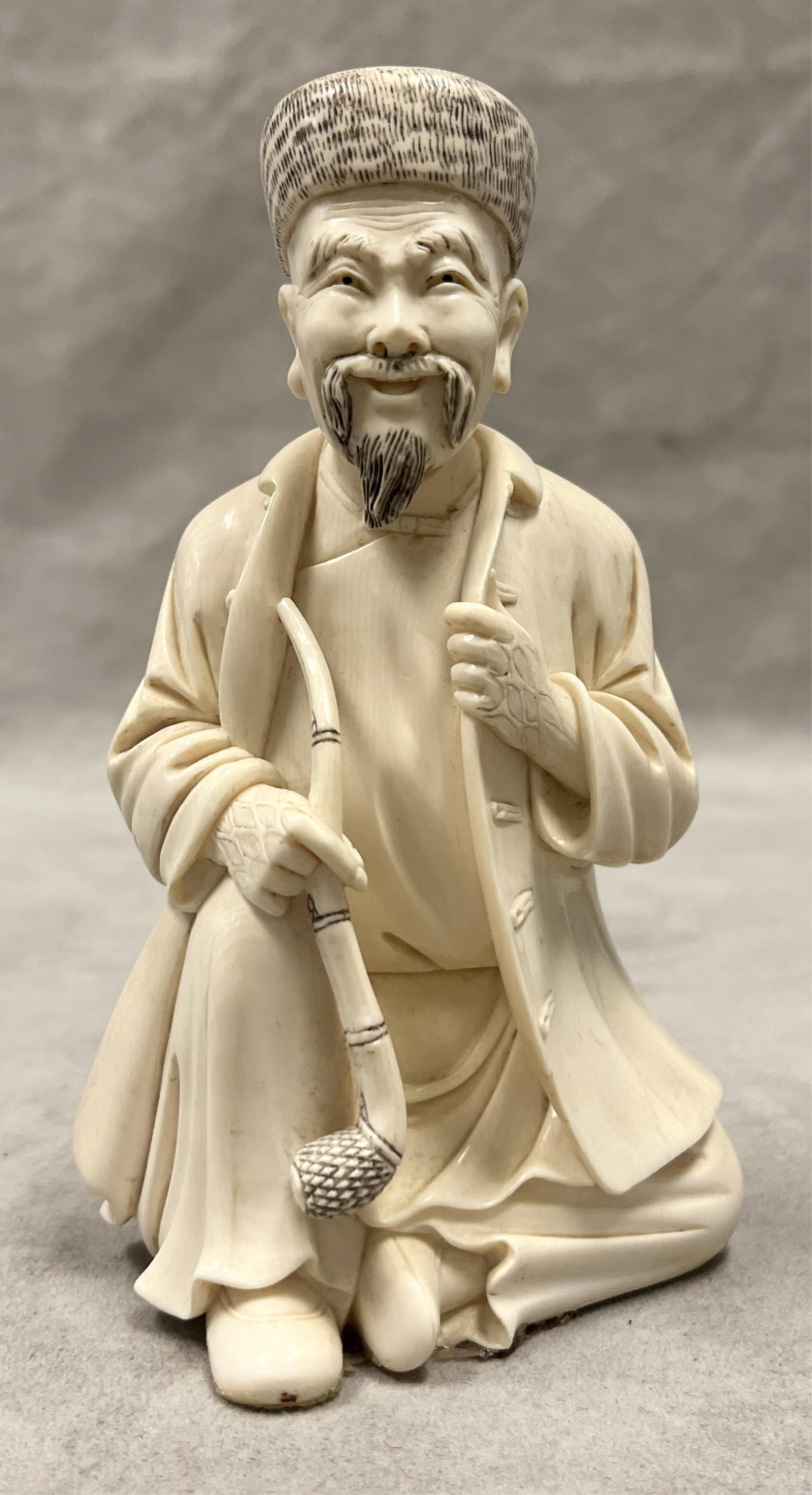 CHINESE CARVING OF SEATED MAN WITH PIPE - H: 6 1/8 in..: CHINESE CARVING OF SEATED MAN WITH PIPE Scrimshaw highlights H: 6 1/8 in. PROVENANCE: ?Merry Hill?, an historic mansion built in 1899 and located in Greenspring Valley, Baltimore County, MD