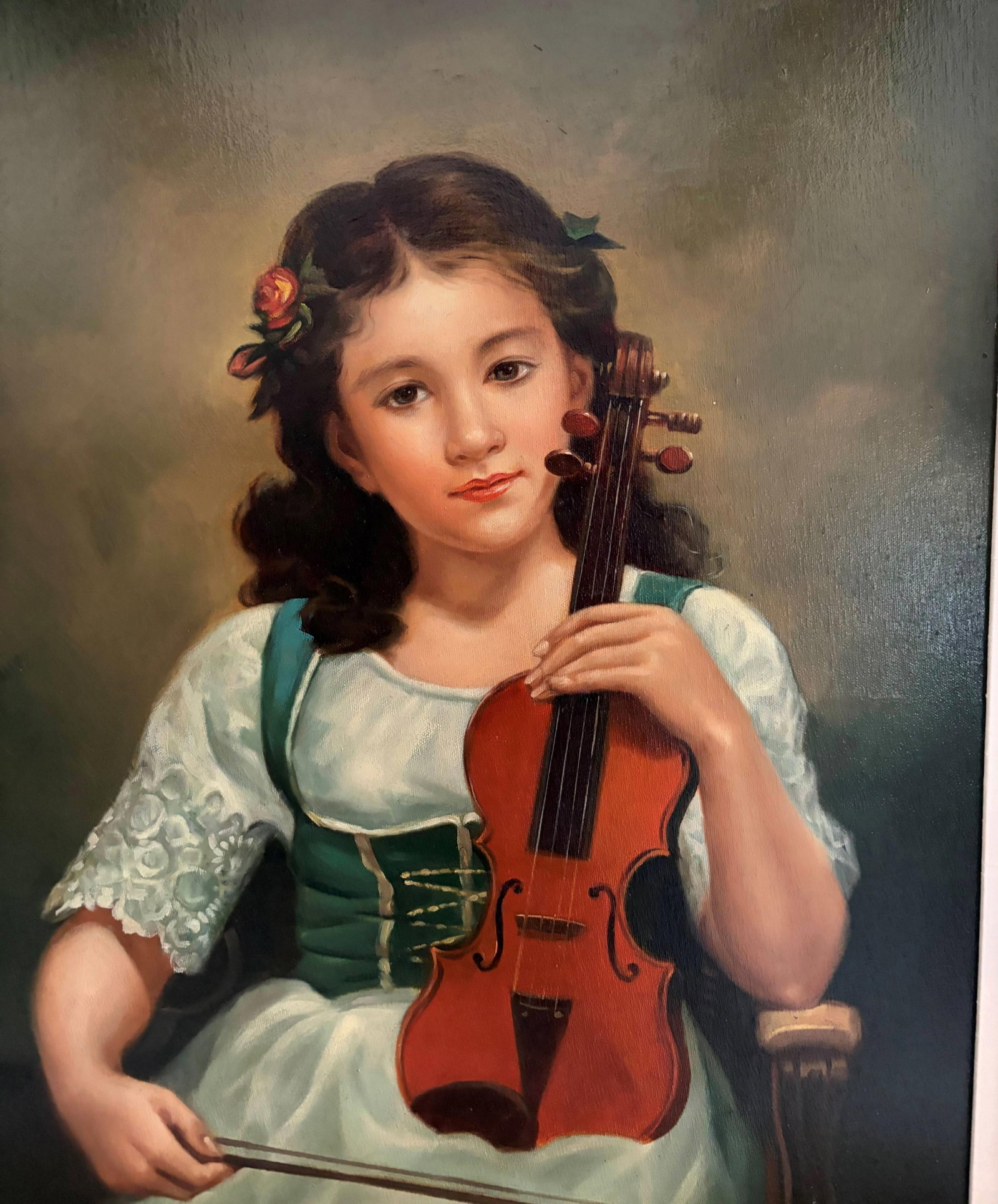 AMERICAN SCHOOL (20th century). Portrait of a Young Girl with a Violin, Oil on canvas, 24 x 20: AMERICAN SCHOOL 20th century Portrait of a Young Girl with a Violin Oil on canvas A painted portrait of a dark-haired young girl in a white lace and green dress, holding a violin and bow, her expressi