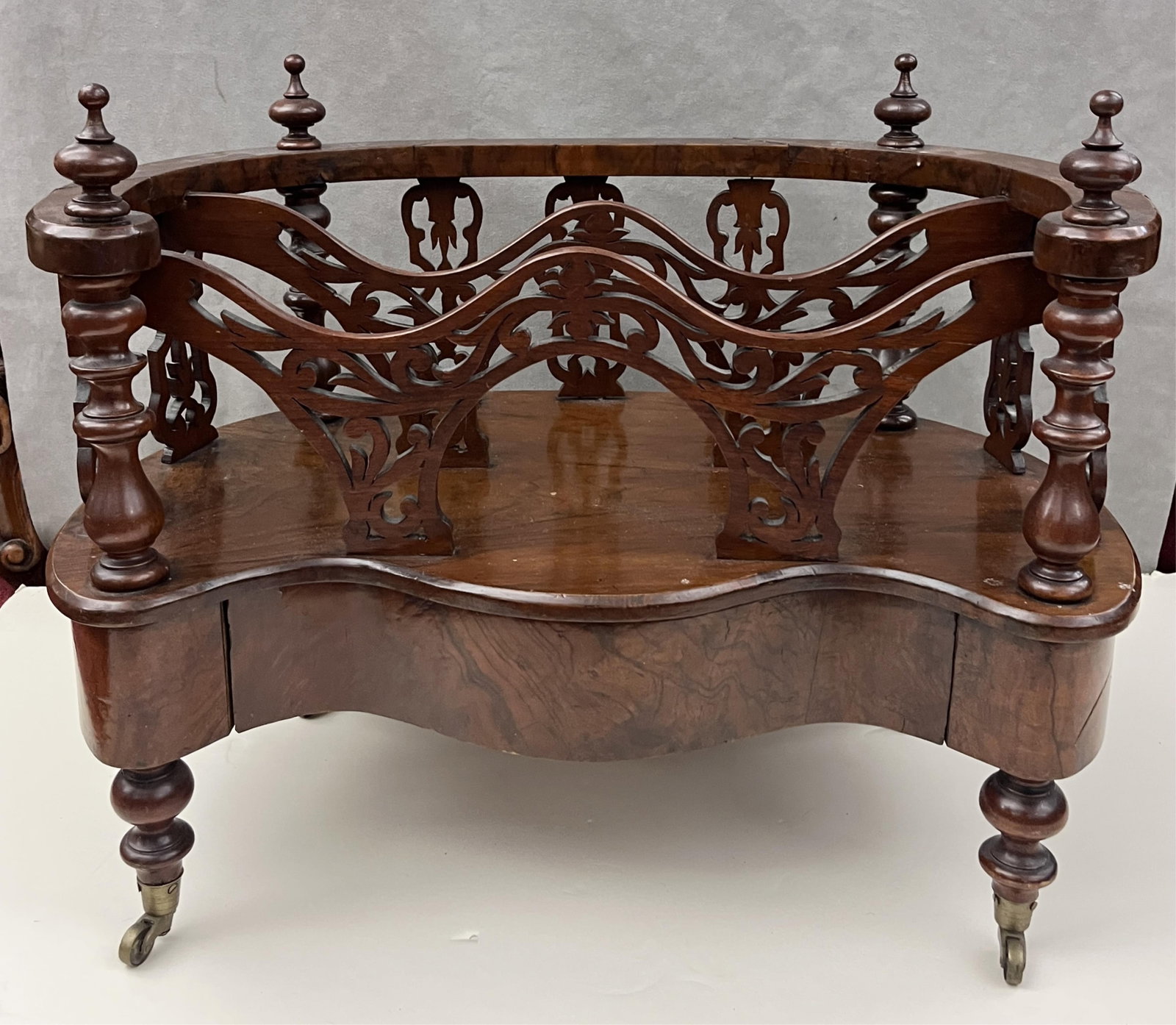 ENGLISH VICTORIAN ROSEWOOD OVAL CANTERBURY WITH SERPENTINE FRONT OUTLINE - H: 22 IN; W: 28 IN; D: 16: ENGLISH VICTORIAN ROSEWOOD OVAL CANTERBURY WITH SERPENTINE FRONT OUTLINE Two compartments over one apron drawer; pierced dividers H: 22 IN; W: 28 IN; D: 16 IN PROVENANCE: ?Merry Hill?, an historic man