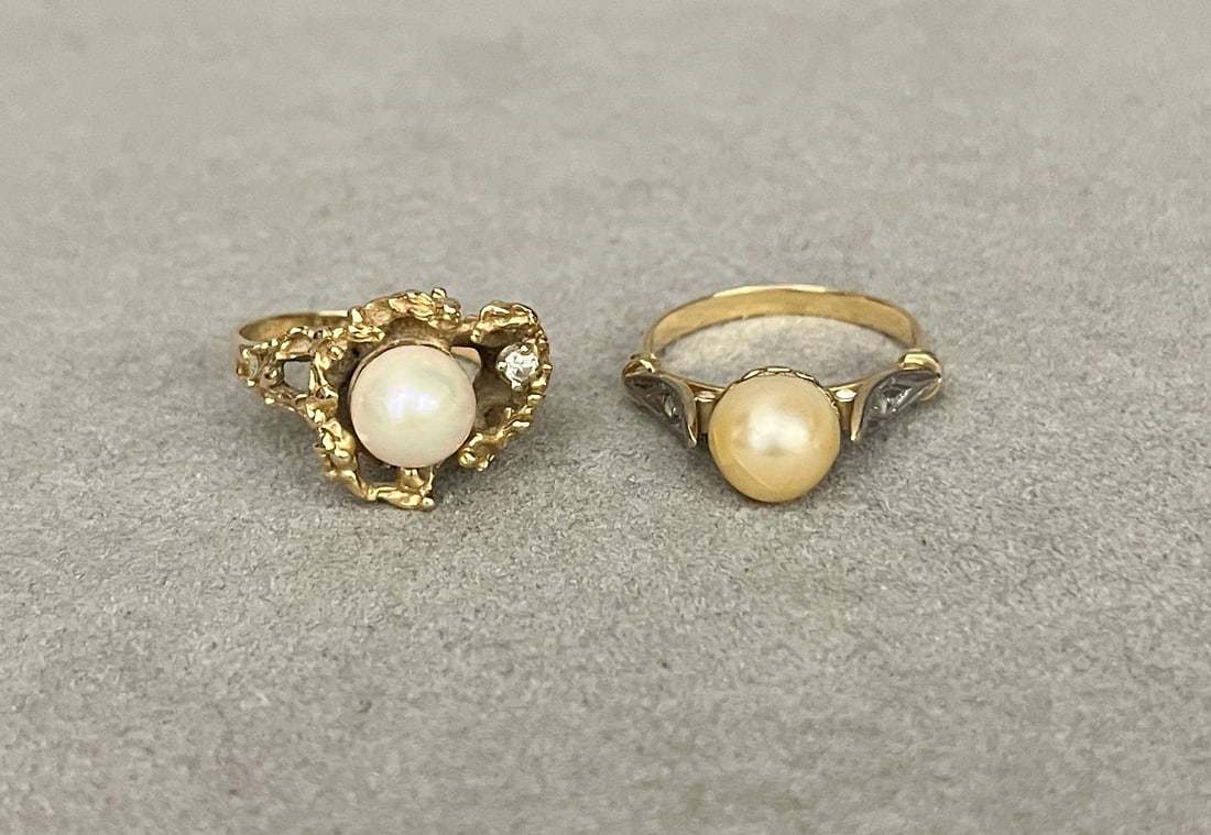 TWO 14K YELLOW GOLD AND CULTURED PEARL RINGS One, with 7.5 mm pearl sided by round diamond in: TWO 14K YELLOW GOLD AND CULTURED PEARL RINGS One, with 7.5 mm pearl sided by round diamond in asymmetrical nugget-textured, openwork setting; other, with 8 mm pearl centered by two rose cut diamonds o