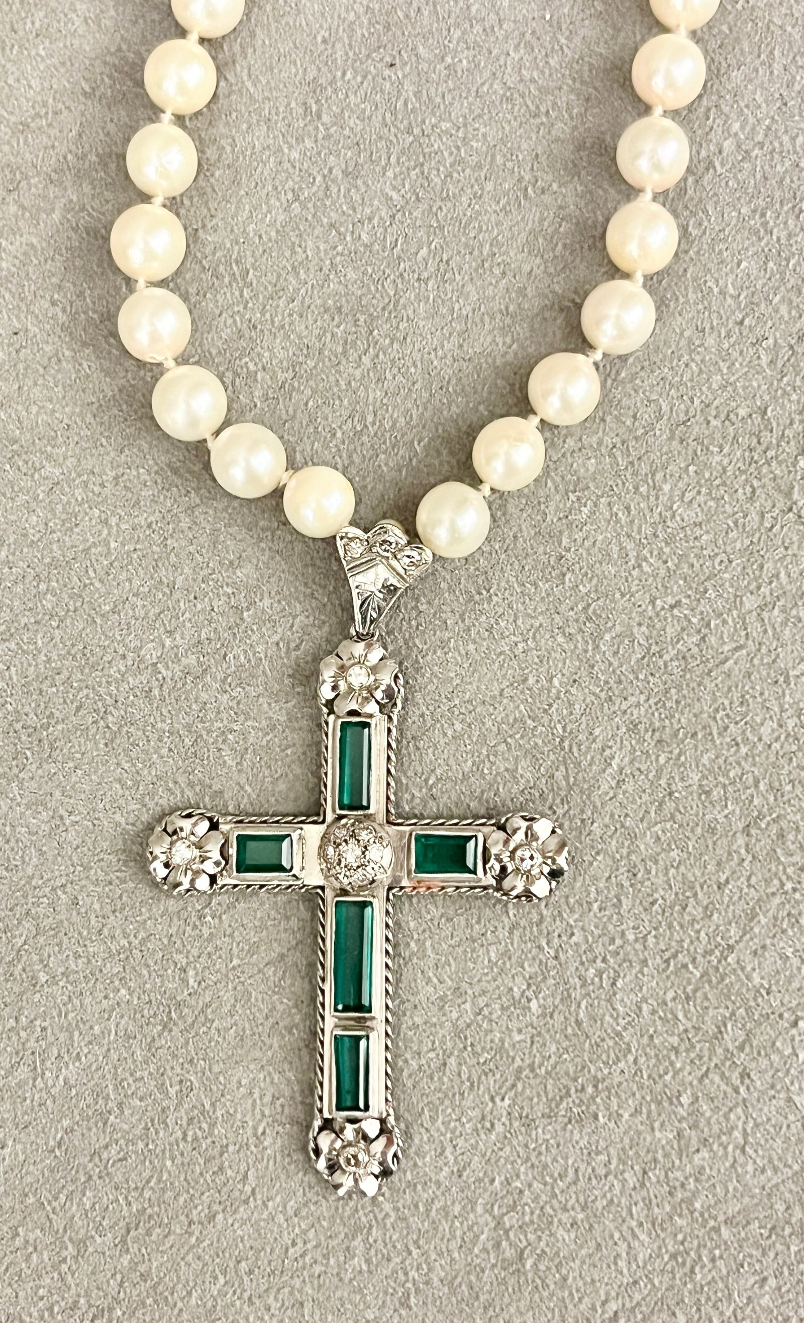 14K WHITE GOLD, EMERALD AND DIAMOND CHRISTIAN CROSS PENDANT SUSPENDED ON MATCHED CULTURED PEARL: 14K WHITE GOLD, EMERALD AND DIAMOND CHRISTIAN CROSS PENDANT SUSPENDED ON MATCHED CULTURED PEARL CHOKER Pendant with bail mounted with five raised, bezel-set rectangular emeralds and 14 round diamonds;