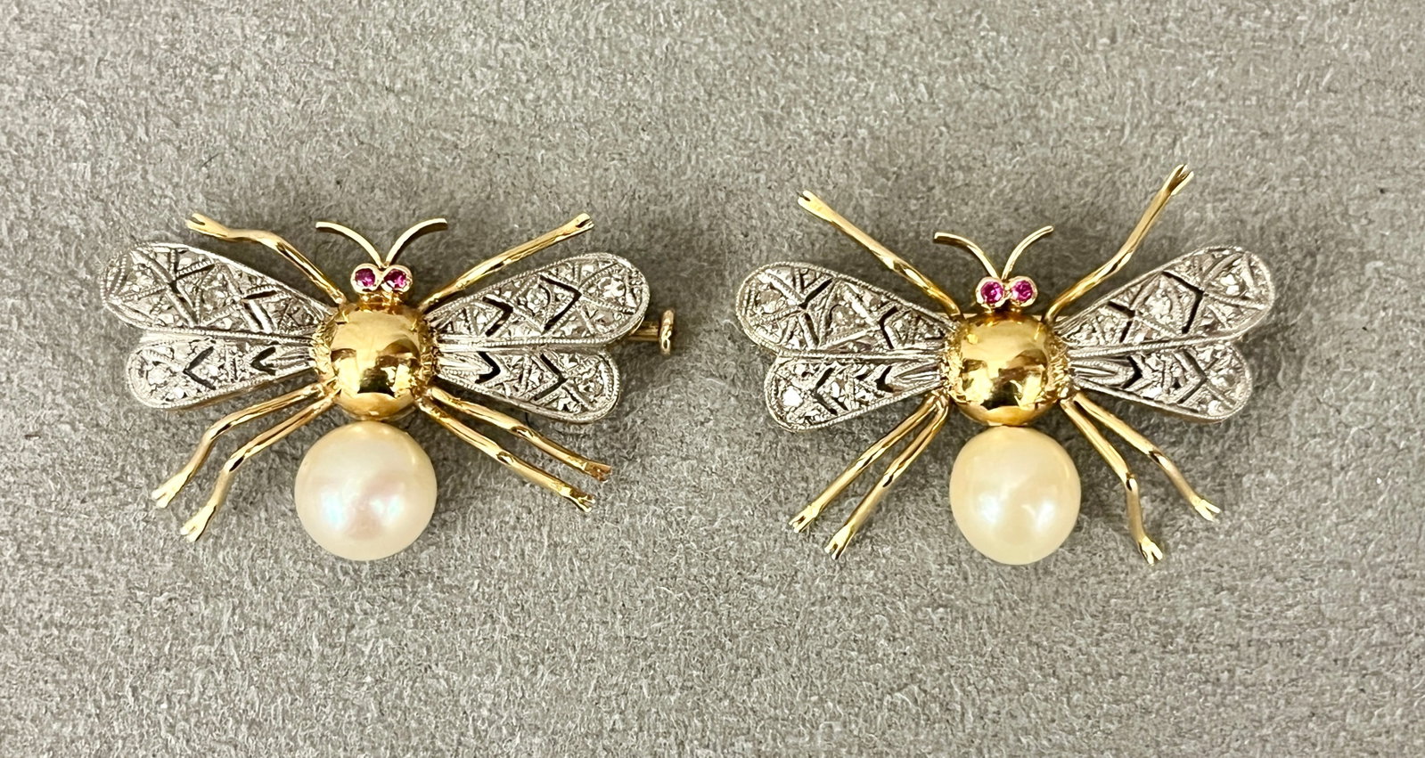 PAIR 18K YELLOW AND WHITE GOLD, DIAMOND, PEARL AND RUBY BEE FORM PINS Each fashioned with yellow: PAIR 18K YELLOW AND WHITE GOLD, DIAMOND, PEARL AND RUBY BEE FORM PINS Each fashioned with yellow gold and cultured pearl body, white gold openwork wings set with melee diamonds, and ruby eyes. W: 1 3/