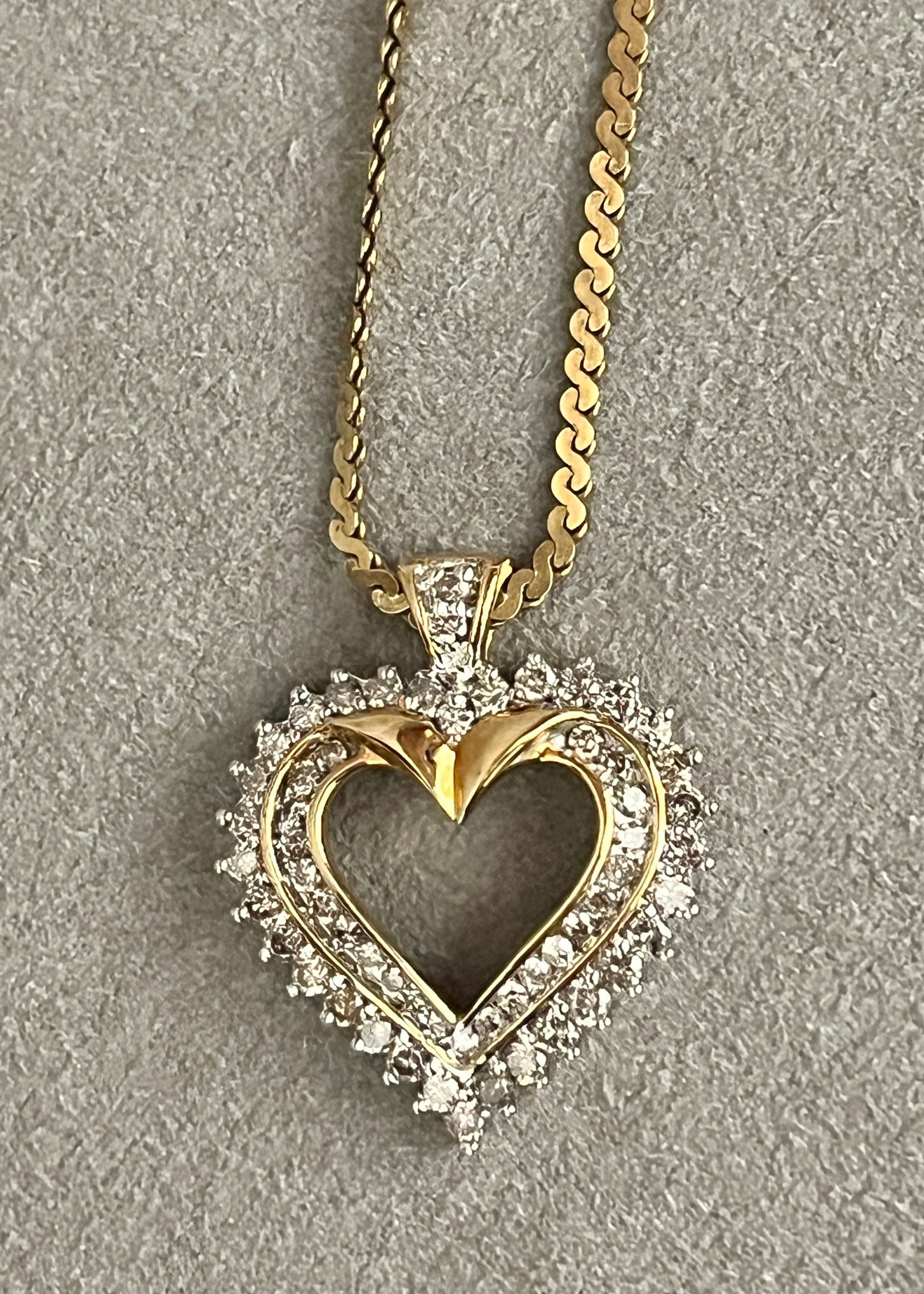 10K YELLOW GOLD AND DIAMOND HEART-SHAPE PENDANT SUSPENDED ON 14K YELLOW GOLD S-LINK CHAIN: 10K YELLOW GOLD AND DIAMOND HEART-SHAPE PENDANT SUSPENDED ON 14K YELLOW GOLD S-LINK CHAIN Open-center heart set with two rows of total of 57 graduated brilliant-cut round diamonds together weighing ap