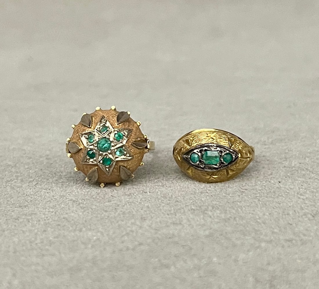 TWO 18K YELLOW GOLD AND EMERALD RINGS One, dome ring with seven round emeralds in applied white: TWO 18K YELLOW GOLD AND EMERALD RINGS One, dome ring with seven round emeralds in applied white gold star shape motif on textured ground. Ring size: 6 1/4. Other, delicate tapering domed band centerin