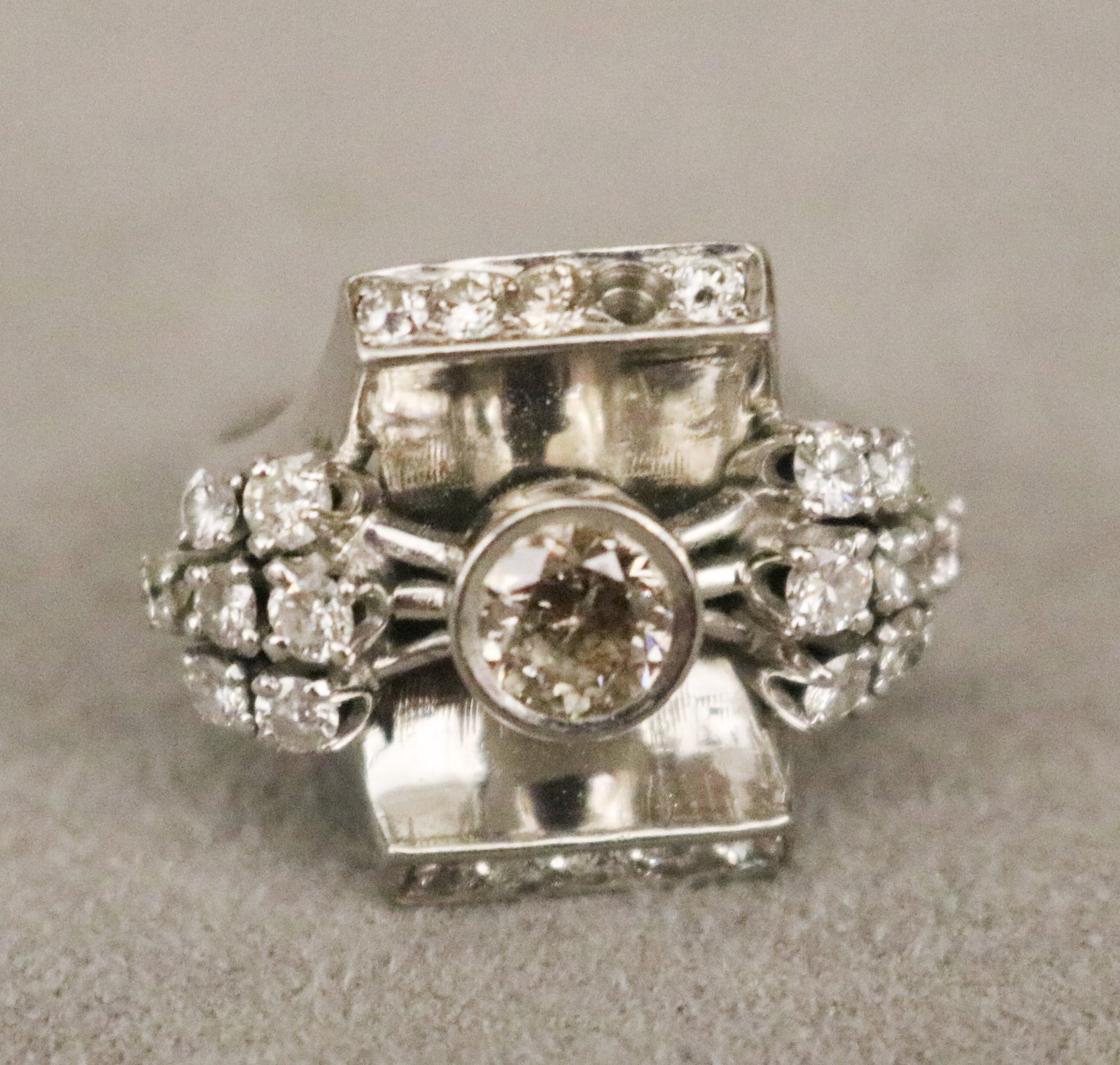 14K WHITE GOLD AND DIAMOND GEOMETRIC DESIGN RING Brilliant-cut round diamond weighing app. 50 ct.,: 14K WHITE GOLD AND DIAMOND GEOMETRIC DESIGN RING Brilliant-cut round diamond weighing app. 50 ct., centered by two bars of nine matched round diamonds, and two clusters of 14 round diamonds in flaring