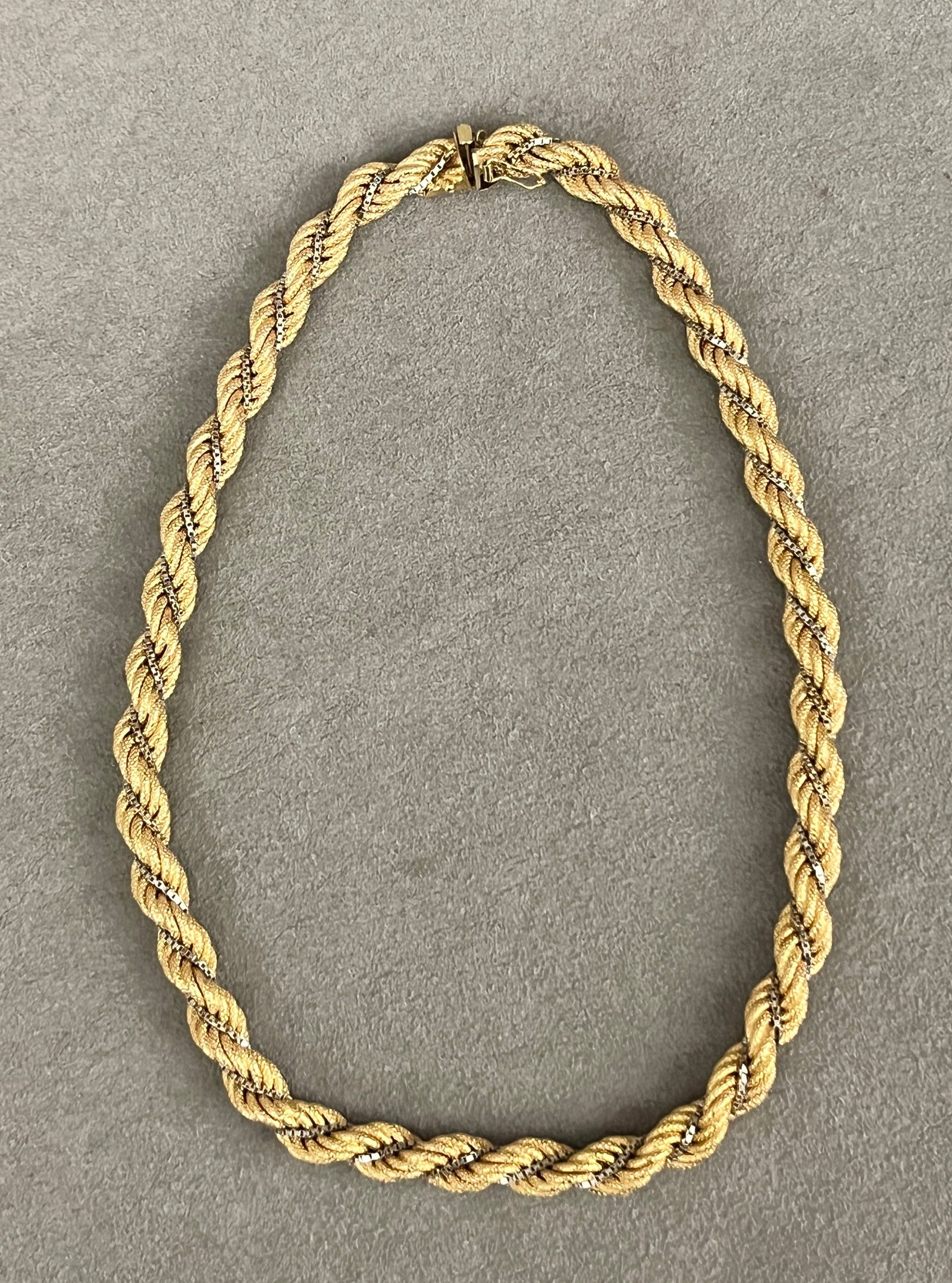 18K (750) YELLOW AND WHITE GOLD FLEXIBLE ROPE CHOKER Textured gold rope entwined with white gold: 18K (750) YELLOW AND WHITE GOLD FLEXIBLE ROPE CHOKER Textured gold rope entwined with white gold box-link chain. L: 15 1/2". Wt: 1 oz. 4 dwt.