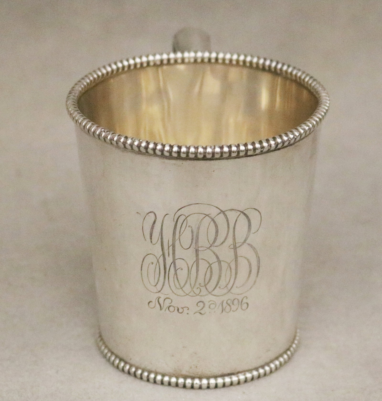 STERLING SILVER FLARING CUP WITH BEADED RIM AND FOOT RETAILED BY J. E. CALDWELL & CO. late 19th: STERLING SILVER FLARING CUP WITH BEADED RIM AND FOOT RETAILED BY J. E. CALDWELL & CO. late 19th century Squared scroll handle, monogrammed H: 3 1/4 in. Wt. 5.8 troy oz.