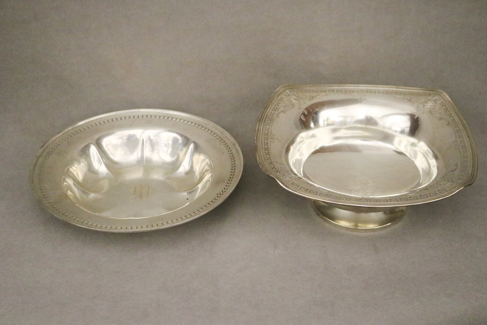 TWO STERLING SILVER SERVING BOWLS early 20th century - Larger, cushion shape, 9 3/4 in. x 9 3/4 in.: TWO STERLING SILVER SERVING BOWLS early 20th century One,circular; one, cushion shape. Pierced border decoration; monogrammed. Larger, cushion shape, 9 3/4 in. x 9 3/4 in. Wt. 21.6 troy oz.