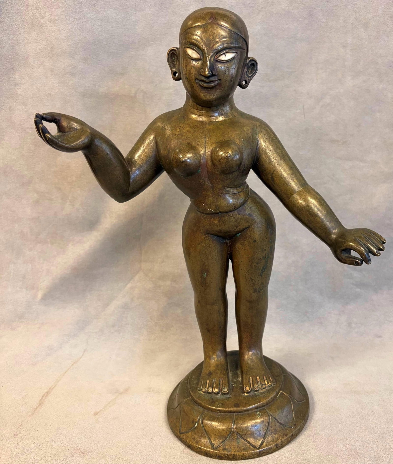 BRASS FIGURE OF RADHA mid-to-late 19th century - height: 14.5 inches.: BRASS FIGURE OF RADHA mid-to-late 19th century Patinated brass figure of Radha from Bengal standing on a lotus base in a graceful pose with one arm extended offering a small bud and the other lowered 