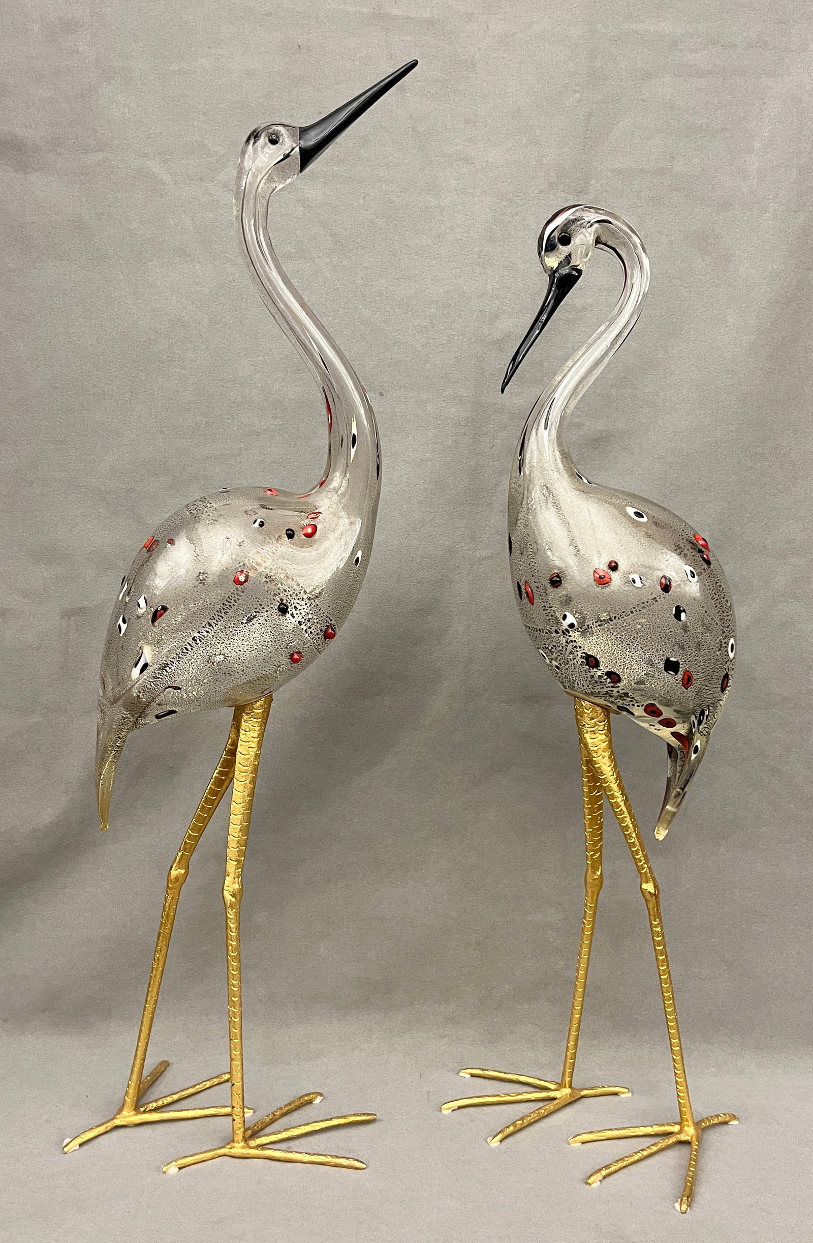 PAIR MURANO ART GLASS SCULPTURES OF CRANES BY LICIO ZANETTI - Taller, H: 29 in..: PAIR MURANO ART GLASS SCULPTURES OF CRANES BY LICIO ZANETTI Colorless bodies with gold flecks; gilt-metal legs; black beaks; red, black and white applied glass accents Taller, H: 29 in.