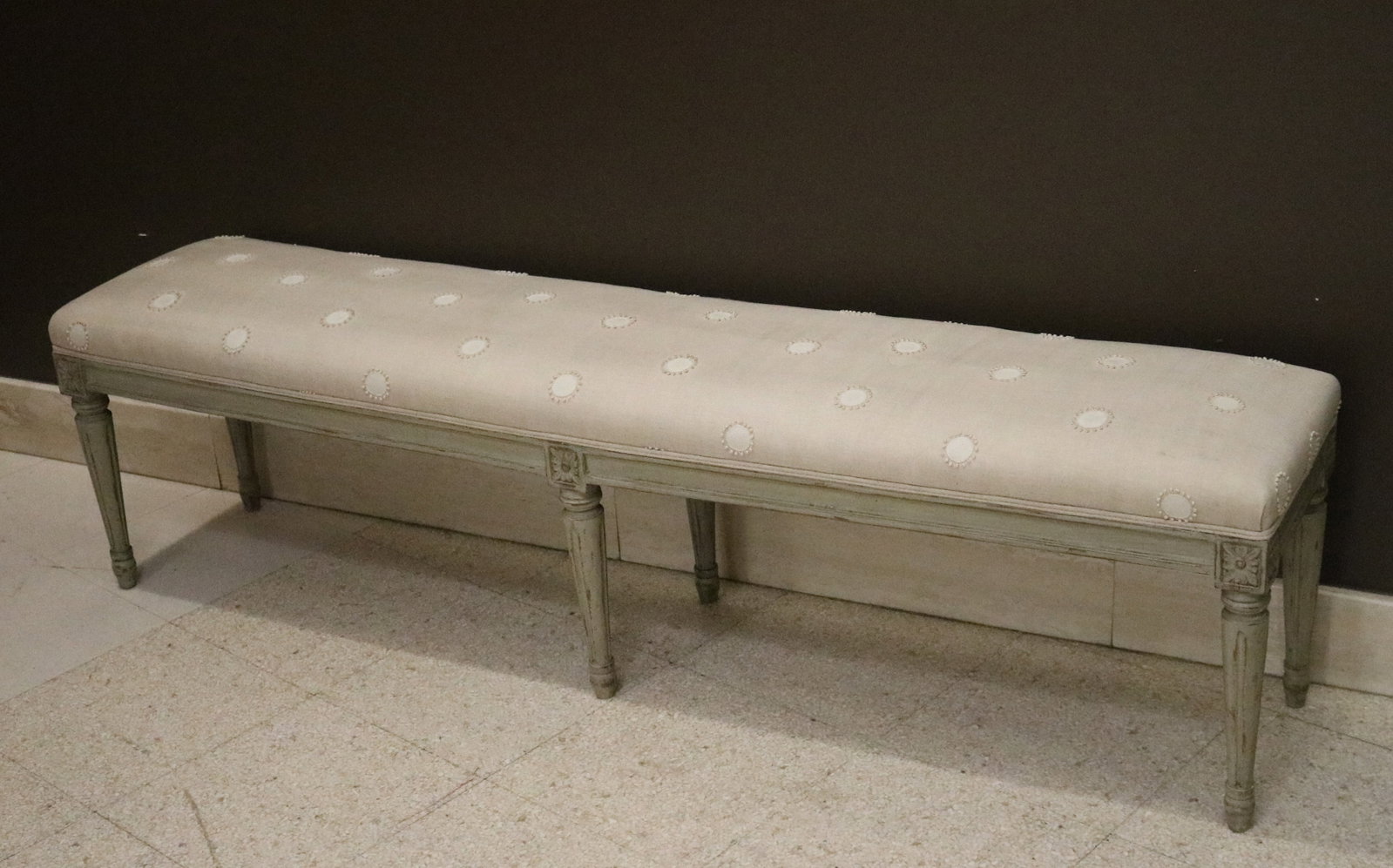 LOUIS XVI STYLE CARVED, GRAY PAINTED AND UPHOLSTERED SIX-LEG BENCH - H: 16 1/2 in L: 61 in. W: 12: LOUIS XVI STYLE CARVED, GRAY PAINTED AND UPHOLSTERED SIX-LEG BENCH Cream-color upholstered with appliqued dots. H: 16 1/2 in L: 61 in. W: 12 3/4 in.