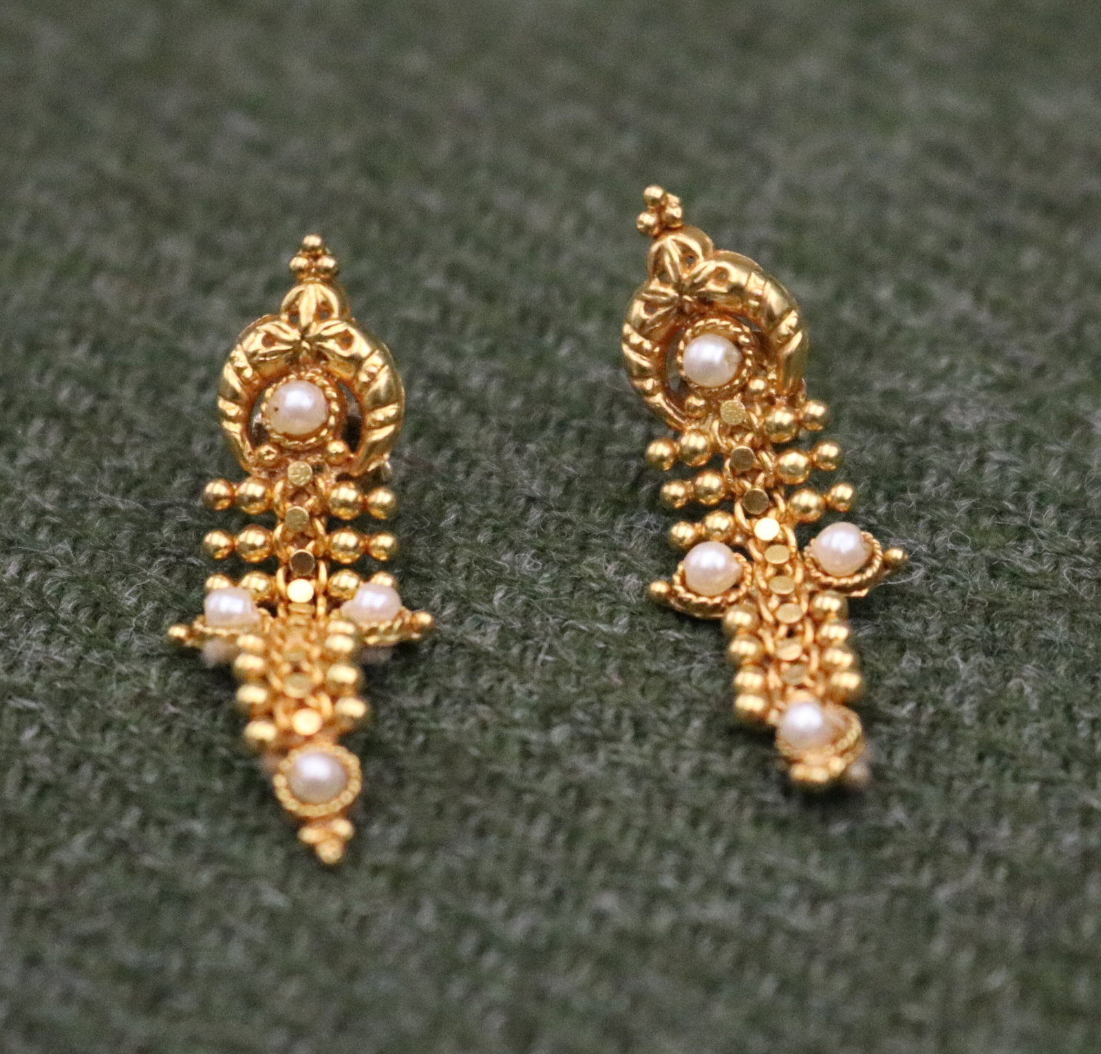 PAIR HIGH KARAT YELLOW GOLD AND SEED PEARL FLEXIBLE STRAP DESIGN POST-BACK EARRINGS - .: PAIR HIGH KARAT YELLOW GOLD AND SEED PEARL FLEXIBLE STRAP DESIGN POST-BACK EARRINGS Each beaded strap set with four seed pearls. L: 1 1/4". Gross wt: 1.5 dwt.