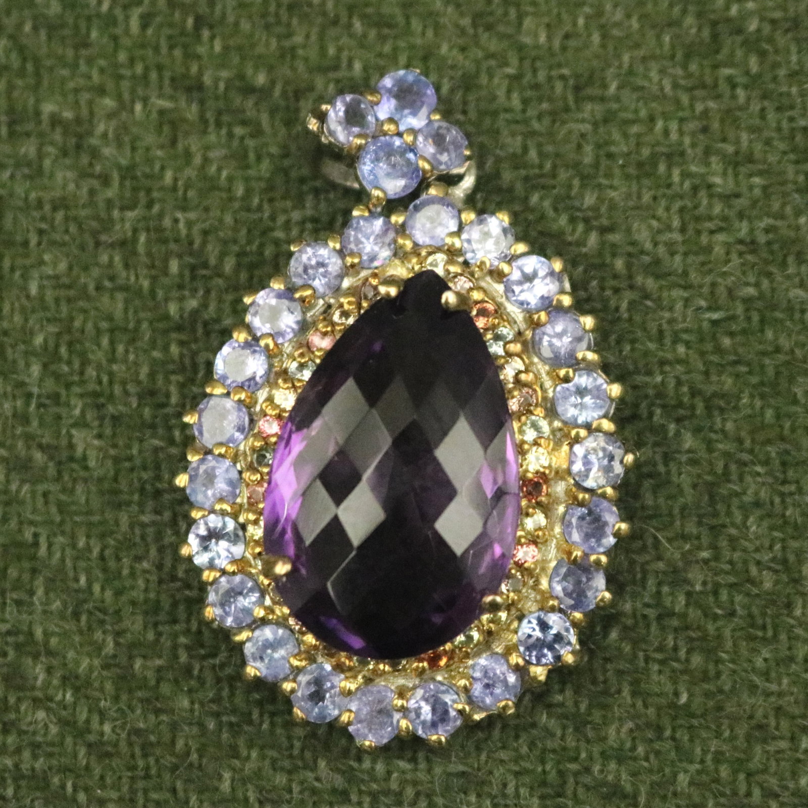 STERLING SILVER, AMETHYST AND OTHER COLORED GEMSTONE OVAL PENDANT - L: 1 7/8 in..: STERLING SILVER, AMETHYST AND OTHER COLORED GEMSTONE OVAL PENDANT Briolette-cut, pear shape amethyst raised and centered by inner border of various colored round gemstones and outer border of pale blu