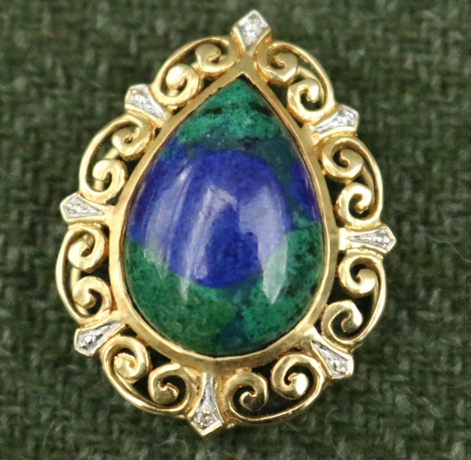 18K YELLOW GOLD, BLUE-AND-GREEN HARD-STONE AND DIAMOND PEAR-SHAPE PENDANT - .: 18K YELLOW GOLD, BLUE-AND-GREEN HARD-STONE AND DIAMOND PEAR-SHAPE PENDANT Bezel-set hardstone centered in scrolling openwork setting with two accent diamonds. L: 1 1/8". Gross wt: 3 dwt.