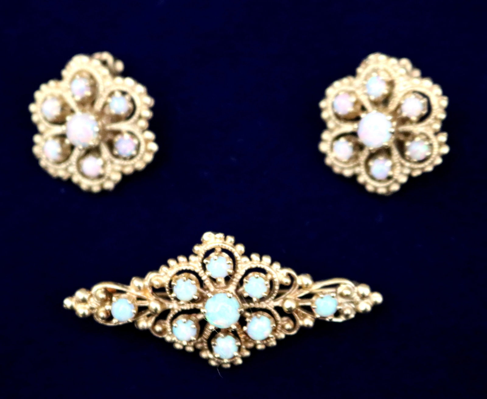 PAIR OF 14K YELLOW GOLD AND PRECIOUS WHITE OPAL FLOWERHEAD DESIGN EARRINGS WITH COORDINATING LOZENGE: PAIR OF 14K YELLOW GOLD AND PRECIOUS WHITE OPAL FLOWERHEAD DESIGN EARRINGS WITH COORDINATING LOZENGE SHAPE PIN Scalloped openwork, clip-back earrings each set with cluster of seven precious white opal