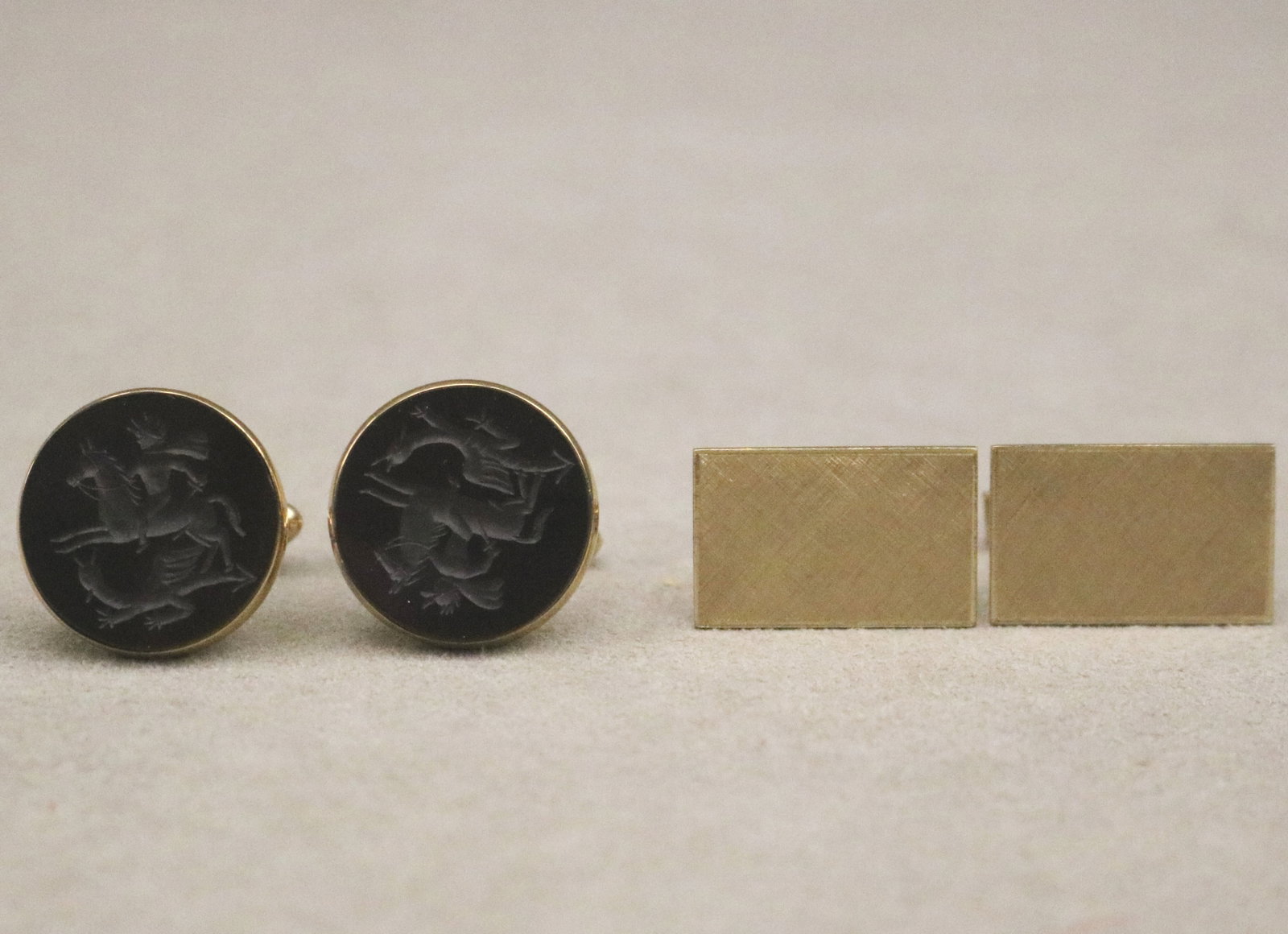 TWO PAIRS 14K YELLOW GOLD WING-BACK CUFFLINKS - Gross wt: 15 dwt..: TWO PAIRS 14K YELLOW GOLD WING-BACK CUFFLINKS One pair, with circular black onyx panel intaglio-cut with scene of St. George and the Dragon; other pair, plain textured gold rectangular panels. Gross w
