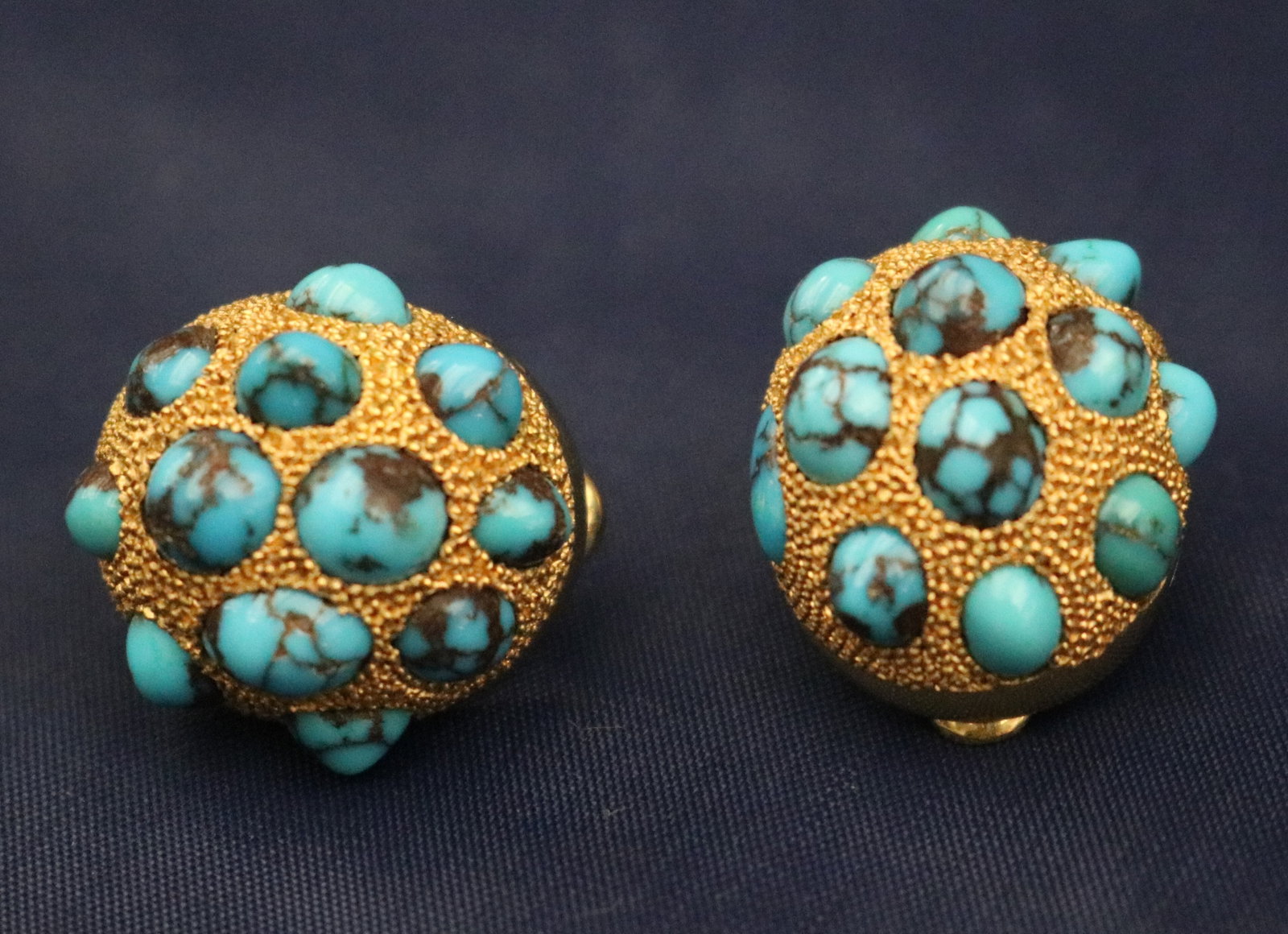 PAIR EGYPTIAN YELLOW GOLD AND TURQUOISE CABOCHON DOMED OVAL CLIP-BACK EARRINGS - .: PAIR EGYPTIAN YELLOW GOLD AND TURQUOISE CABOCHON DOMED OVAL CLIP-BACK EARRINGS Each earring set with 12 round and oval turquoise cabochons on delicately beaded ground. L: 7/8". Gross wt: 11 dwt.