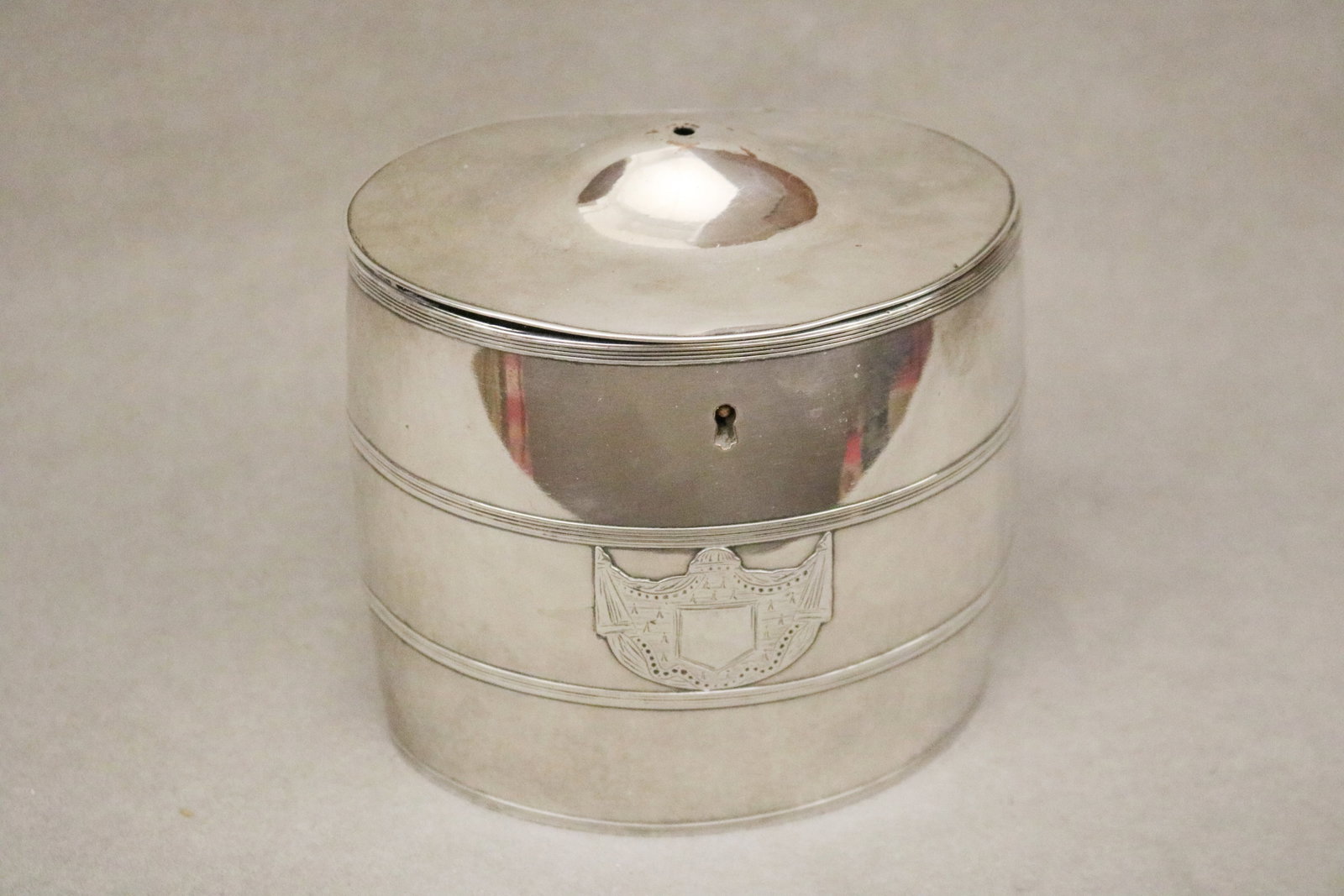 NEOCLASSICAL SHEFFIELD OVAL BARREL-FORM TEACADDY late 18th century - .: NEOCLASSICAL SHEFFIELD OVAL BARREL-FORM TEACADDY late 18th century Unmarked. Two reeded mid-bands center applied drapery swag-and-shield decoration.