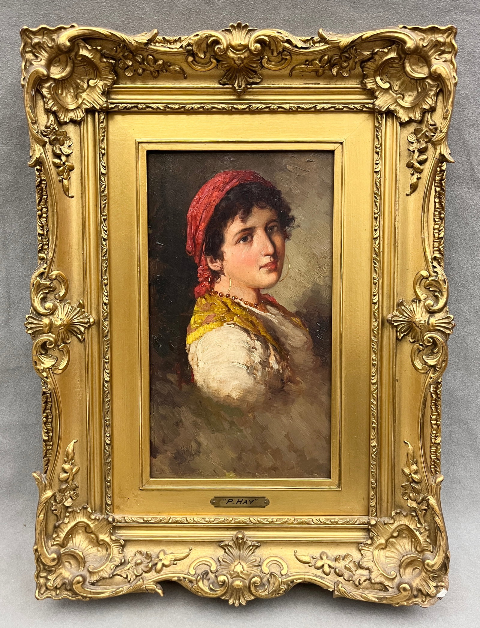 PETER ALEXANDER HAY (Scottish, 1866-1952). Portrait of a Roma Girl, Oil on board, 11 x 6 inches;: PETER ALEXANDER HAY Scottish, 1866-1952 Portrait of a Roma Girl Oil on board Signed lower left. Artwork depicting a dark-haired young woman in Roma costume: a red kerchief tied over her curls, gold ho
