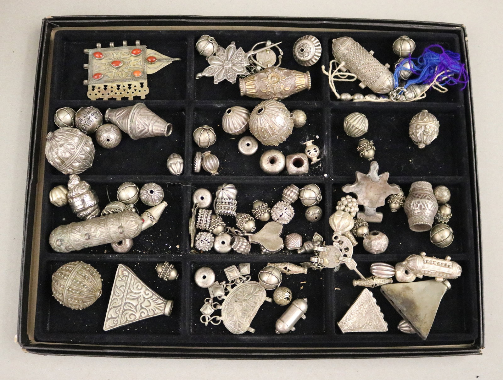 COLLECTION OF SILVER-TONE TRIBAL AMULET CASES, JEWELRY MAKER'S STUDIO - .: COLLECTION OF SILVER-TONE TRIBAL AMULET CASES, JEWELRY MAKER'S STUDIO Lot of silver-tone ethnic metal beads, amulet cases, and pendant components from a jewelry maker's studio. Notable pieces include 