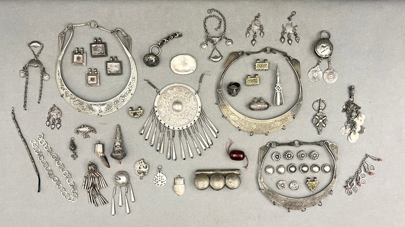 COLLECTION OF TIBETAN AND ETHNIC SILVERED ORNAMENTS - .: COLLECTION OF TIBETAN AND ETHNIC SILVERED ORNAMENTS Collection features a wide array of silvered jewelry and ritual adornments, predominantly from Tibetan, Himalayan, and Central Asian tribal traditio