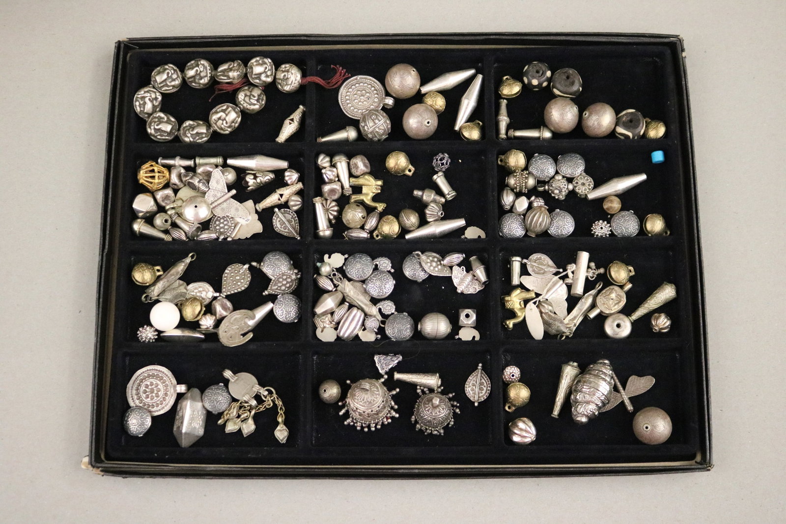 LARGE COLLECTION OF ETHNIC METAL BEADS, CHARMS & PENDANTS; SILVER-TONE AND GILT, JEWELRY MAKER'S: LARGE COLLECTION OF ETHNIC METAL BEADS, CHARMS & PENDANTS; SILVER-TONE AND GILT, JEWELRY MAKER'S STUDIO An extensive lot of loose ethnic-style metal beads, charms, and pendant components originating f