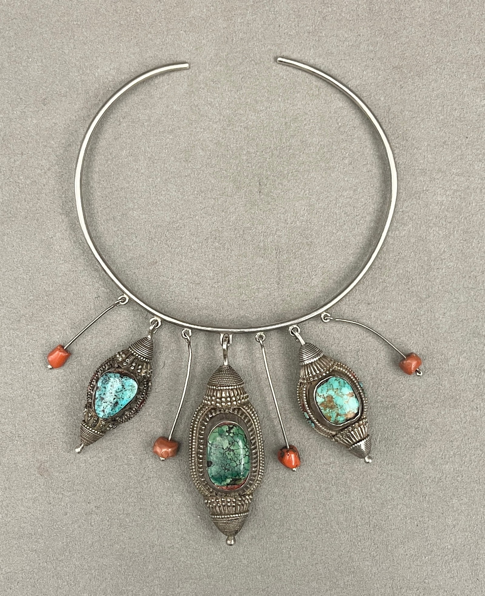 TIBETAN / HIMALAYAN TURQUOISE AND CORAL TORQUE NECKLACE, - .: TIBETAN / HIMALAYAN TURQUOISE AND CORAL TORQUE NECKLACE Tribal-inspired torque collar necklace featuring a rigid silver open neck ring supporting three main drop pendants and four suspended silver wir
