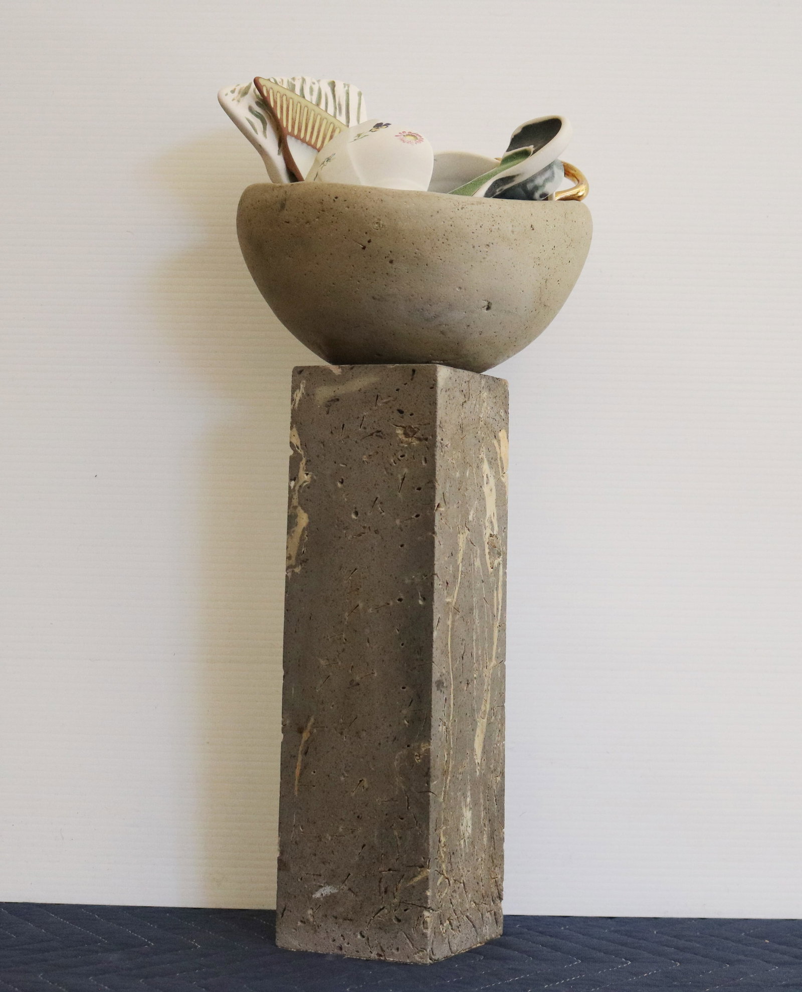 BRAD MILLER (American, born 1950). Vessel of Fragments, Cast concrete pedestal and ceramic bowl,: BRAD MILLER American, born 1950 Vessel of Fragments Cast concrete pedestal and ceramic bowl Signed "Brad Miller AR" under the base. concrete pedestal and ceramic bowl holding an assemblage of broken p