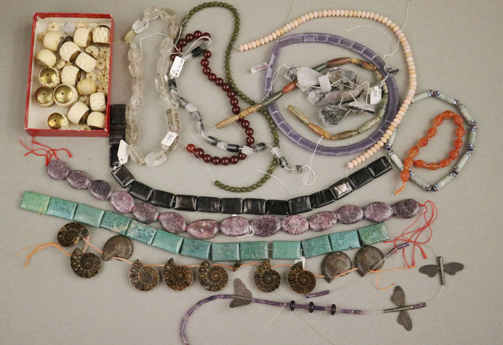 EXTENSIVE COLLECTION OF GEMSTONE BEADING STRANDS, AMMONITE FOSSILS & CARVED BONE BEADS, JEWELRY: EXTENSIVE COLLECTION OF GEMSTONE BEADING STRANDS, AMMONITE FOSSILS & CARVED BONE BEADS, JEWELRY MAKER'S STUDIO Varied lot of loose gemstone bead strands, fossil beads, and carved bone/horn components 