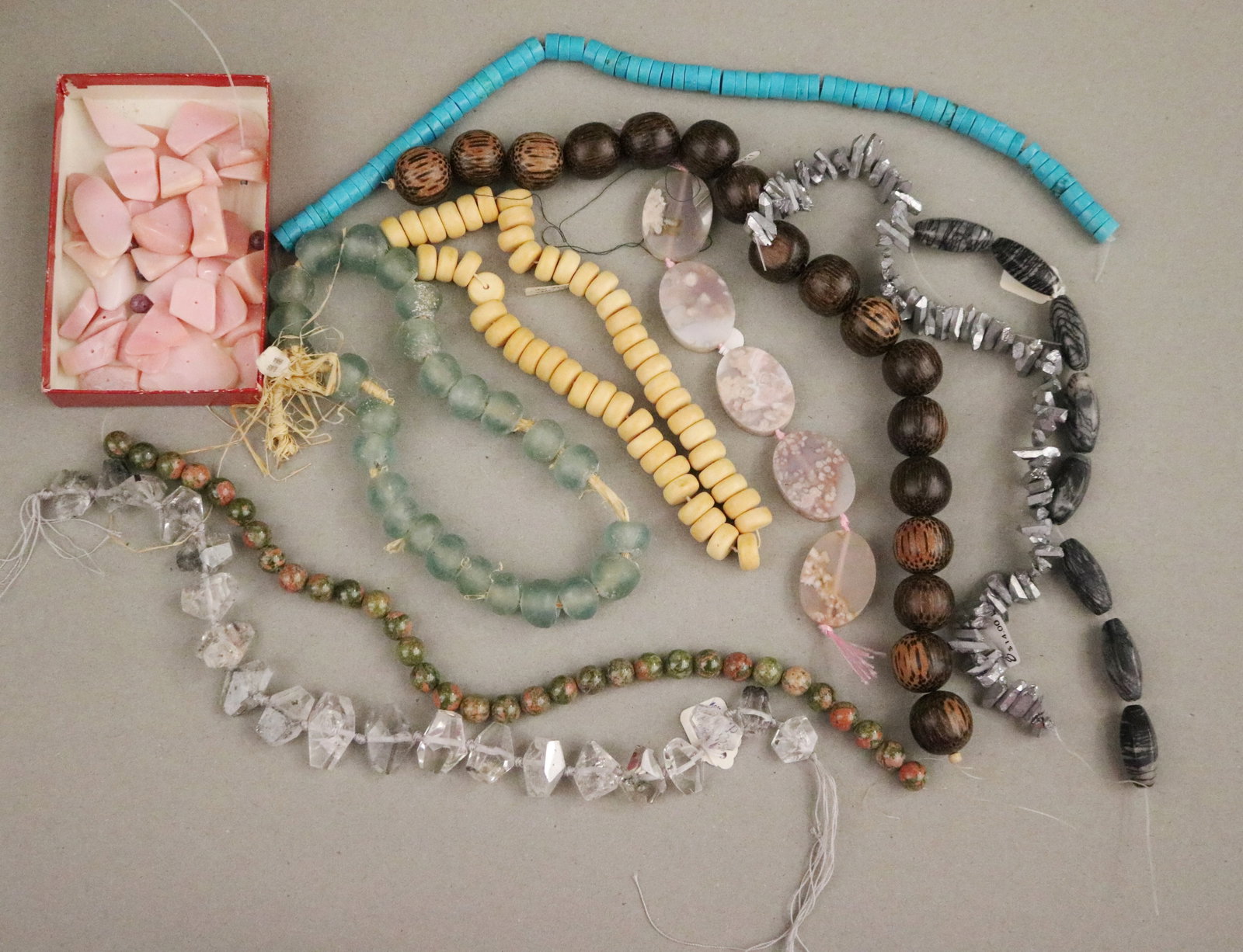 COLLECTION OF WOOD, STONE & GLASS BEADING STRANDS; JEWELRY MAKER'S STUDIO - .: COLLECTION OF WOOD, STONE & GLASS BEADING STRANDS; JEWELRY MAKER'S STUDIO Diverse lot of loose beading strands and a small box of pink shell/stone chip beads from a jewelry maker's studio; Approximate