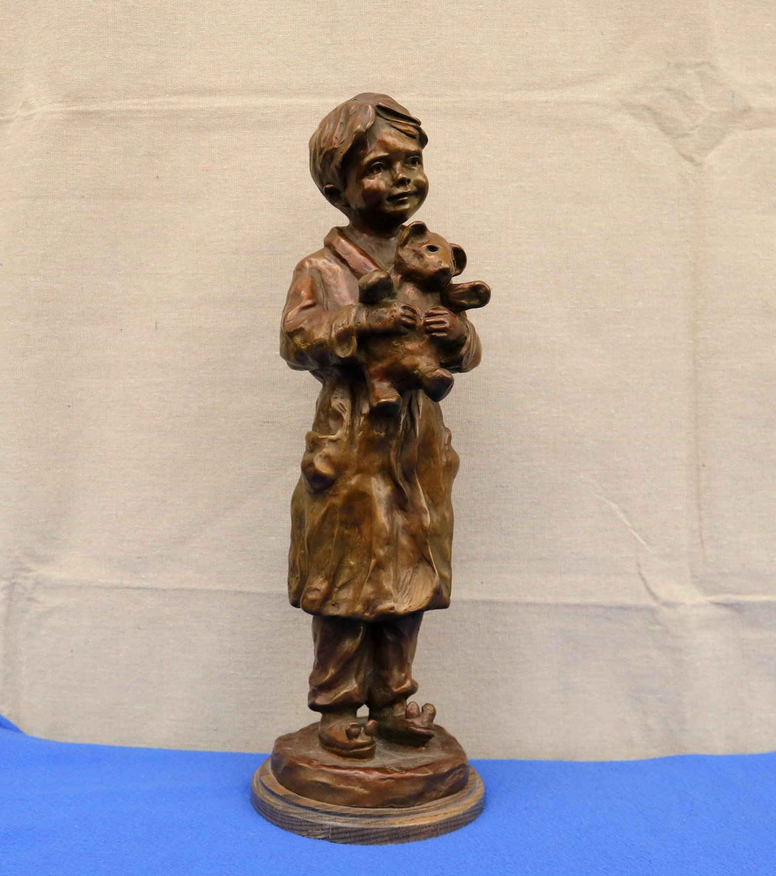 JANE RANKIN (American, 1945-2019). Bedtime" by Jane Rankin, 1992, Bronze, height (including wooden: JANE RANKIN American, 1945-2019 Bedtime" by Jane Rankin, 1992 Bronze Sculpture depicting a young child standing in a nightgown, gazing upward with a gentle smile while cradling a teddy bear close to h