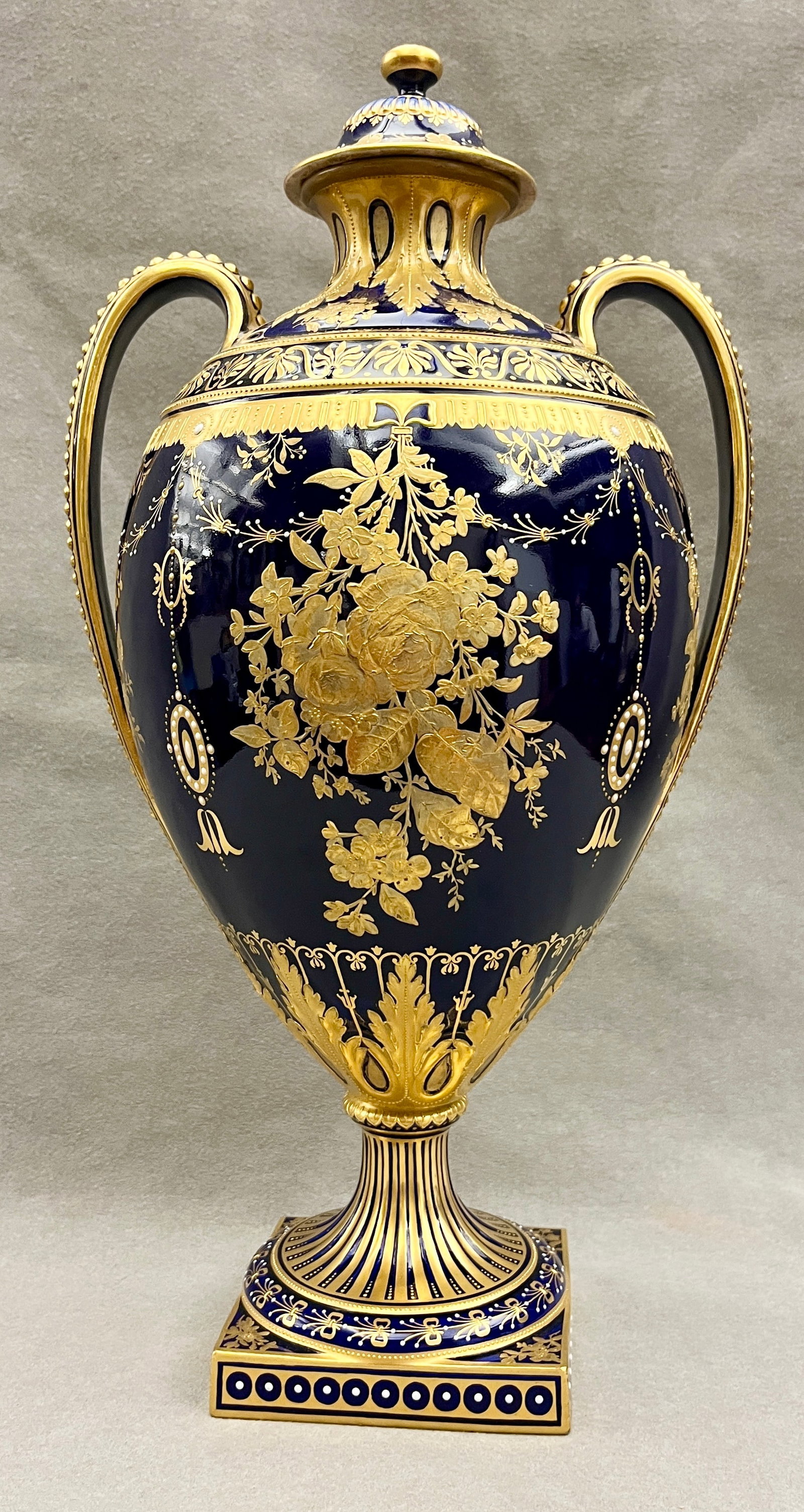 ROYAL CROWN DERBY COBALT GLAZED PORCELAIN LIFT-COVER TWO-HANDLE FOOTED URN 19th century - H: 15 1/4: ROYAL CROWN DERBY COBALT GLAZED PORCELAIN LIFT-COVER TWO-HANDLE FOOTED URN 19th century Lavish gilt decoration of floral sprays, Neoclassical pendants, swags and foliage H: 15 1/4 in.