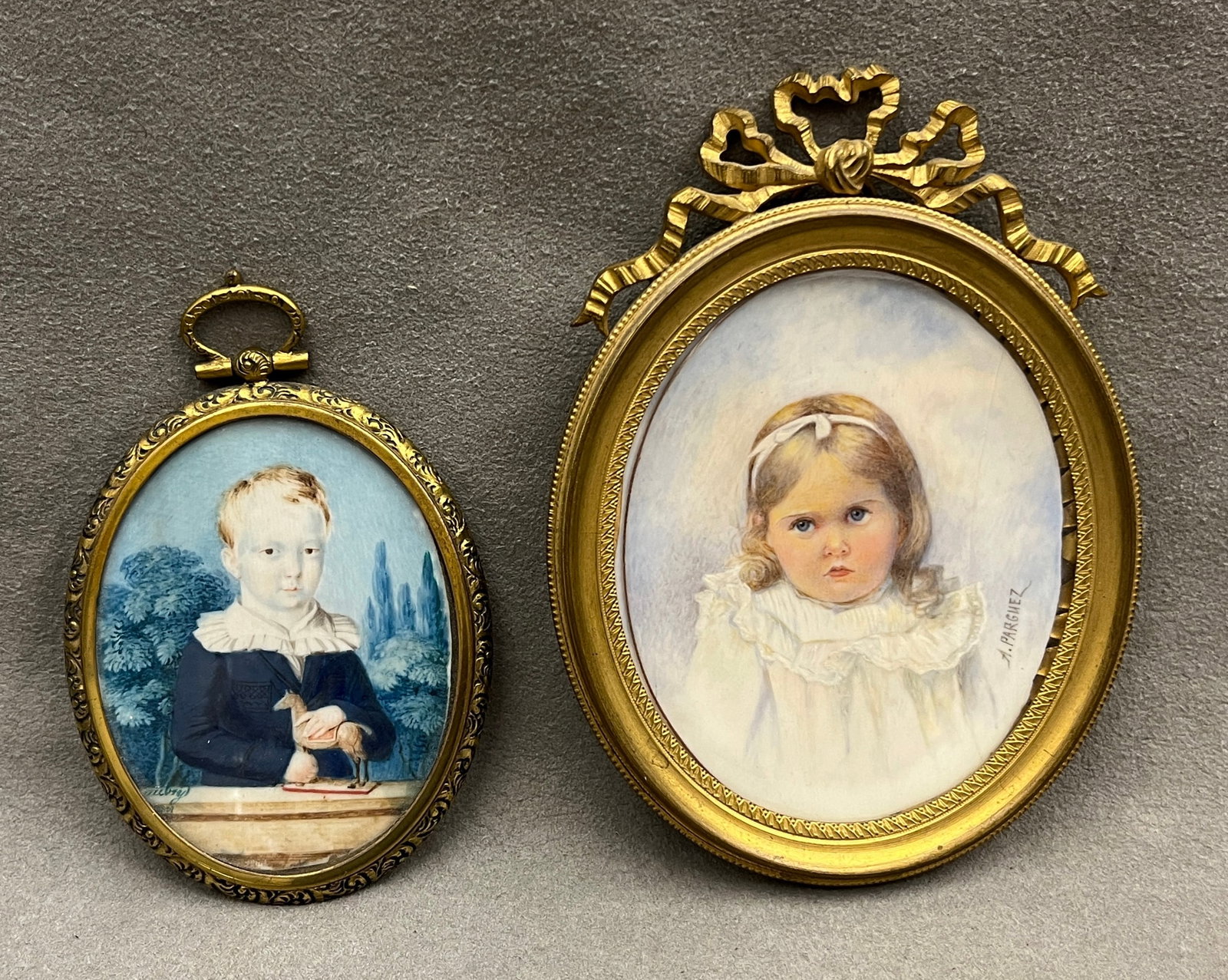 PAIR CONTINENTAL PORTRAIT MINIATURES OF CHILDREN IN GILT BRONZE OVAL FRAMES, ONE SIGNED A. PARGUEZ -: PAIR CONTINENTAL PORTRAIT MINIATURES OF CHILDREN IN GILT BRONZE OVAL FRAMES, ONE SIGNED A. PARGUEZ A pair of miniature portraits on ivorine/paper depicting young children, one a fair-haired boy in a