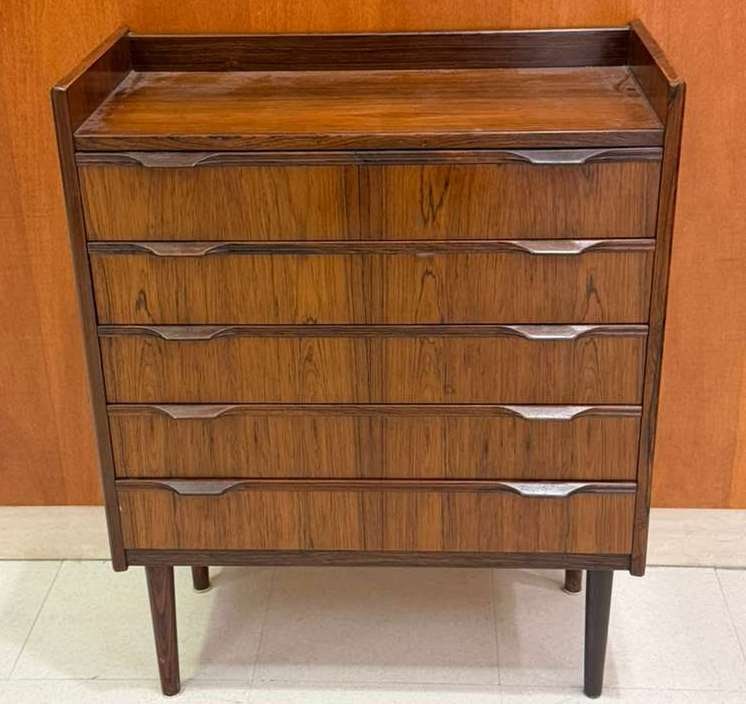 MID-CENTURY MODERN DANISH ROSEWOOD FIVE-DRAWER CHEST Circa 1960 - H: 29 1/2"; W: 23 1/4"; D: 11: MID-CENTURY MODERN DANISH ROSEWOOD FIVE-DRAWER CHEST Circa 1960 Top drawer bears label of NR. Uttrup Boligmontering. Galleried top over five full-width drawers with intergrated projecting wood panels.