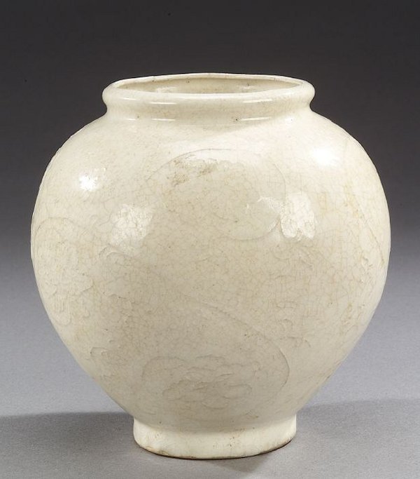 A CHINESE CREAM GLAZED PORCELAIN VASE. O: A CHINESE CREAM GLAZED PORCELAIN VASE. Of ovoid-form with flower-heads and scrolling foliage in low relief - 6 3/4 in. high.