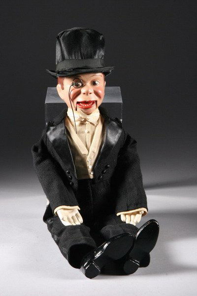 CHARLIE MCCARTHY VENTRILOQUIST DOLL AND BOOKLET. B: CHARLIE MCCARTHY VENTRILOQUIST DOLL AND BOOKLET. By Effanbee. Composition head, hands and feet; muslin body; mounted monocle. Jointed jaw with pull mechanism. Clothes sewn to body; with hat. With six-