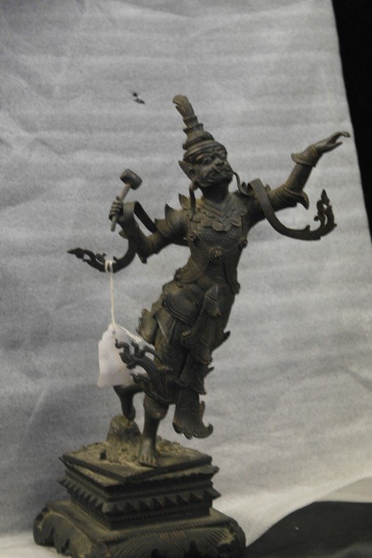 bronze Sino Thai mahakal: A 19th c Burmese moving mahakal piece holding a hammer in right hand and gracefully extending the left hand out. Robes are flowing in a graceful movement as the right foot steps forward and left foot 